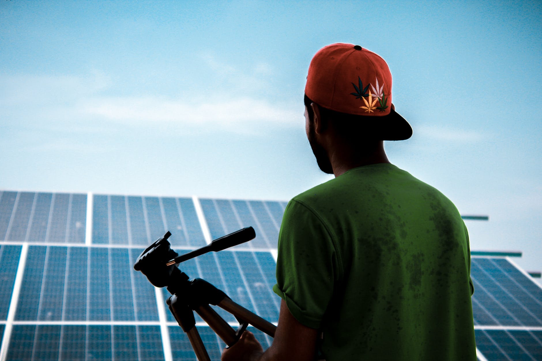 Experiential  education. Photo of back of person with cap looking at solar panels