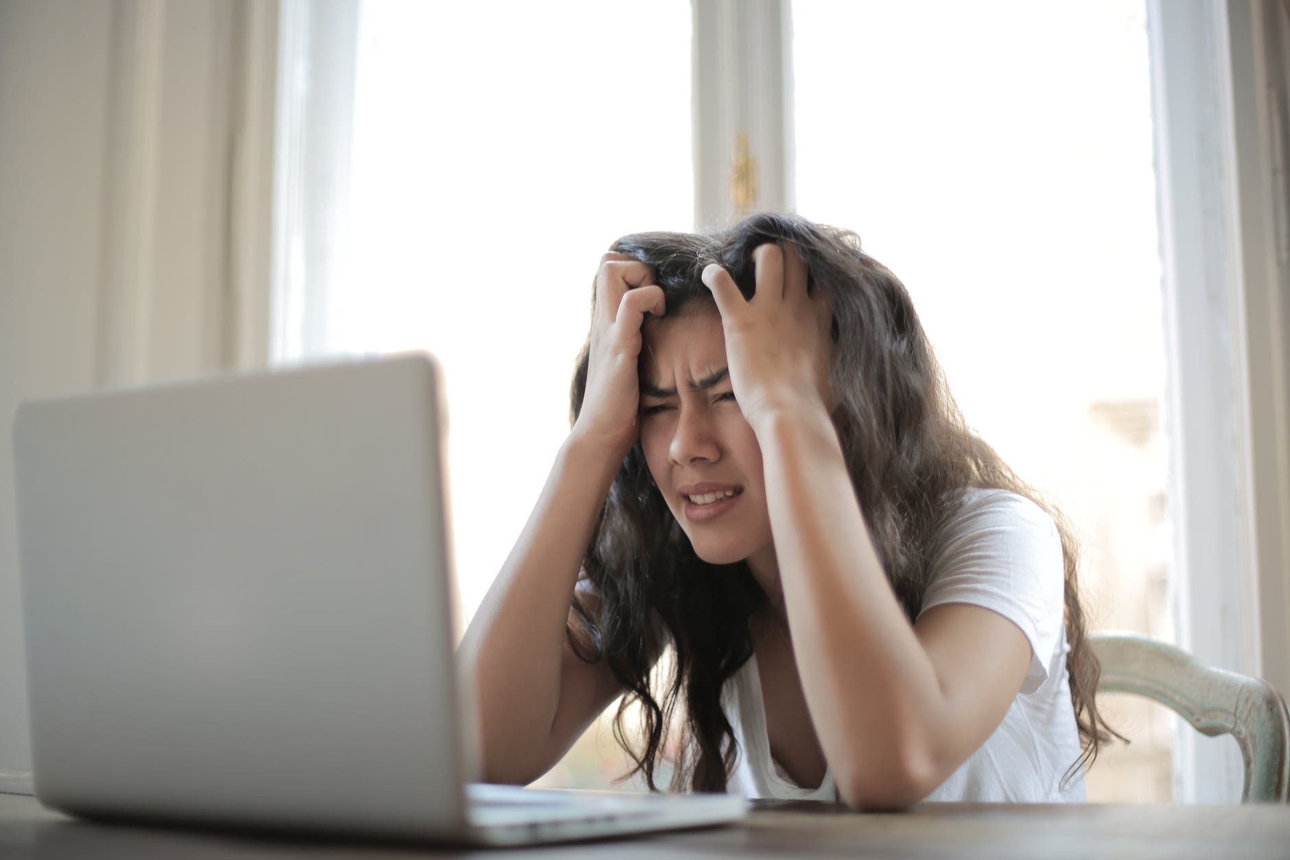 Woman frustrated in front of laptop.