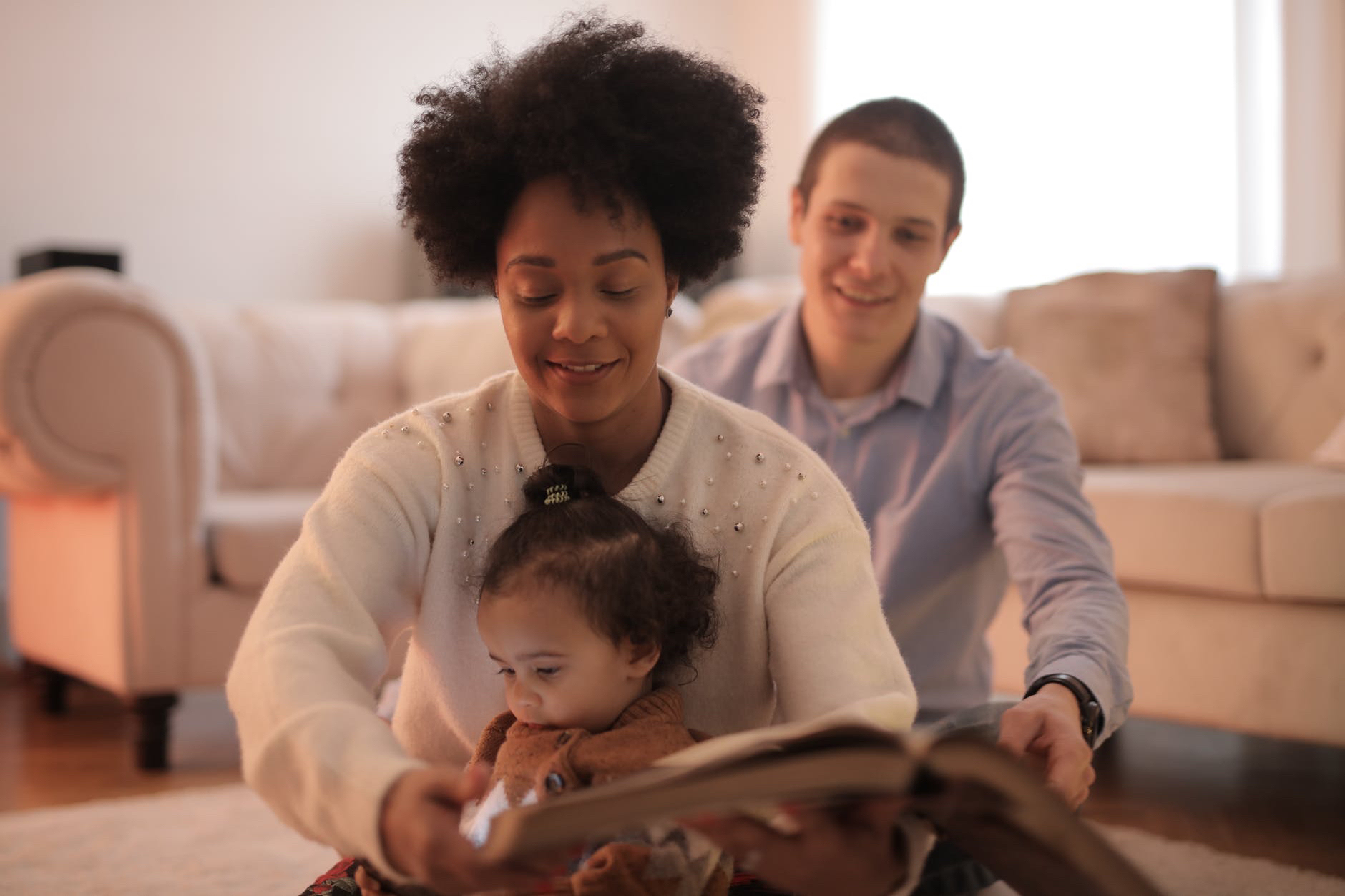 Storytelling . Mother, child, and dad reading book
