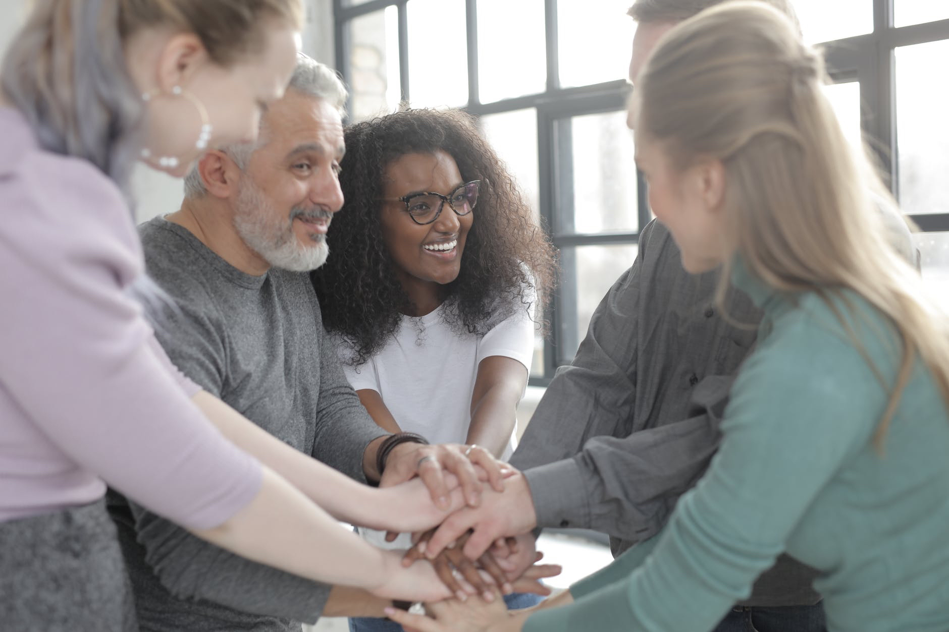 Course-based service learning. Photo of several people holding hands.