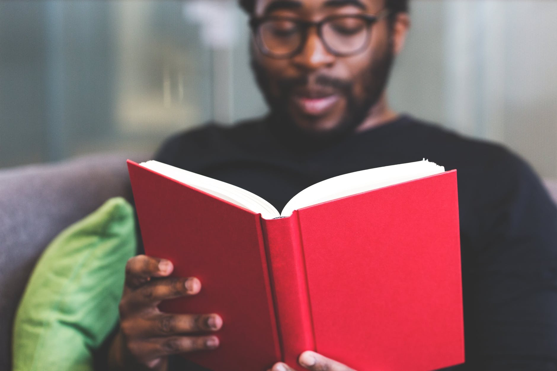 Black man with beard reading textbook 