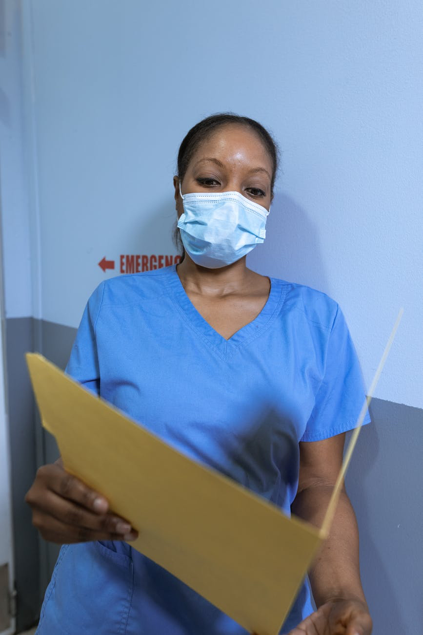 Doctor wearing mask and holding folder