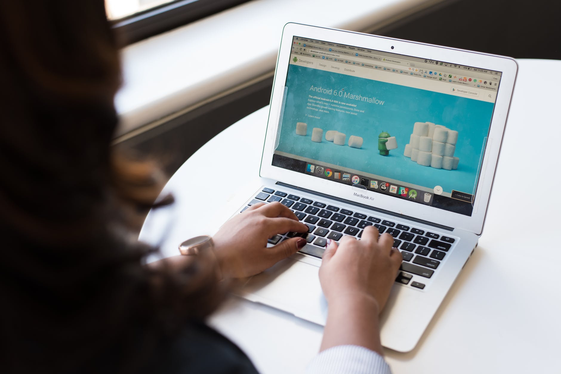 Photo of open laptop and hands on keyboard.