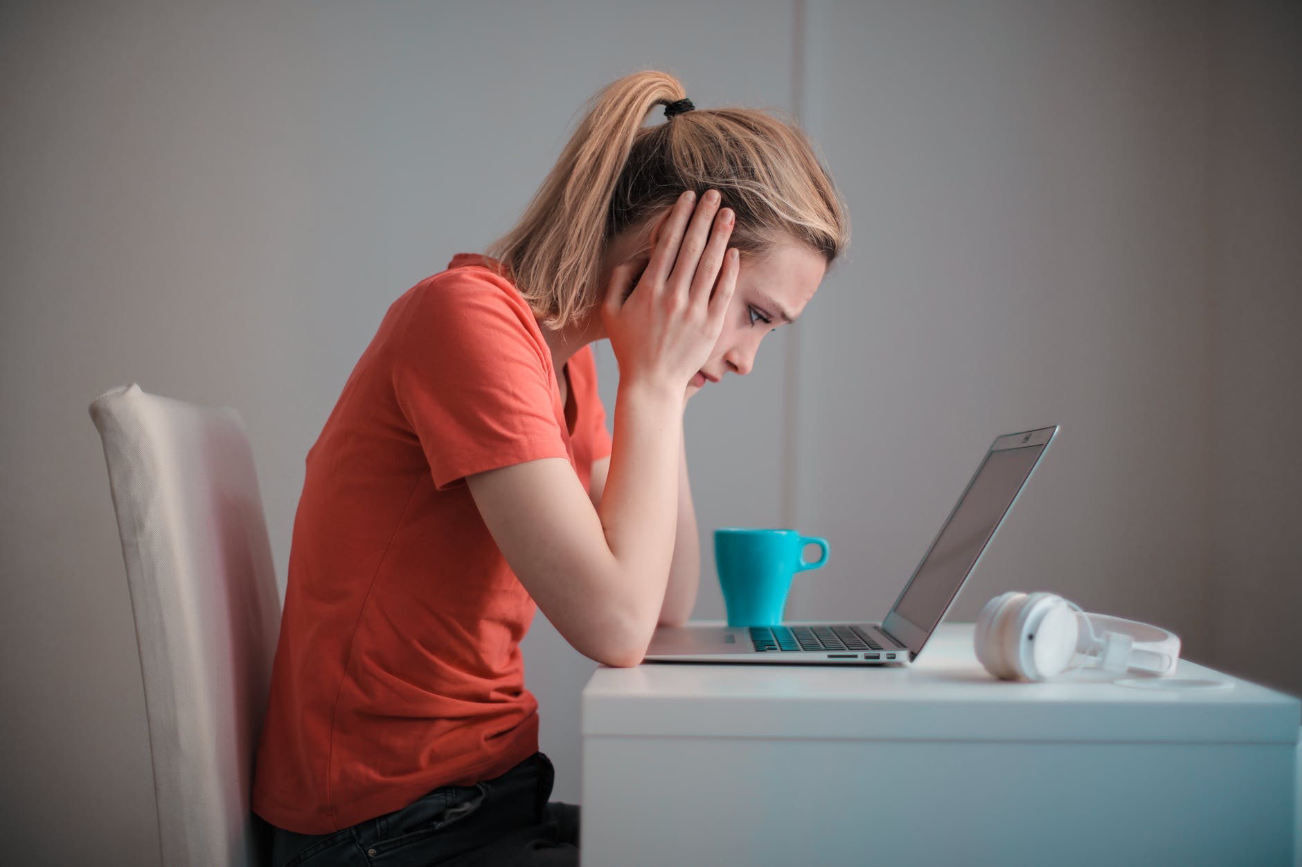 Woman thinking in front of laptop.