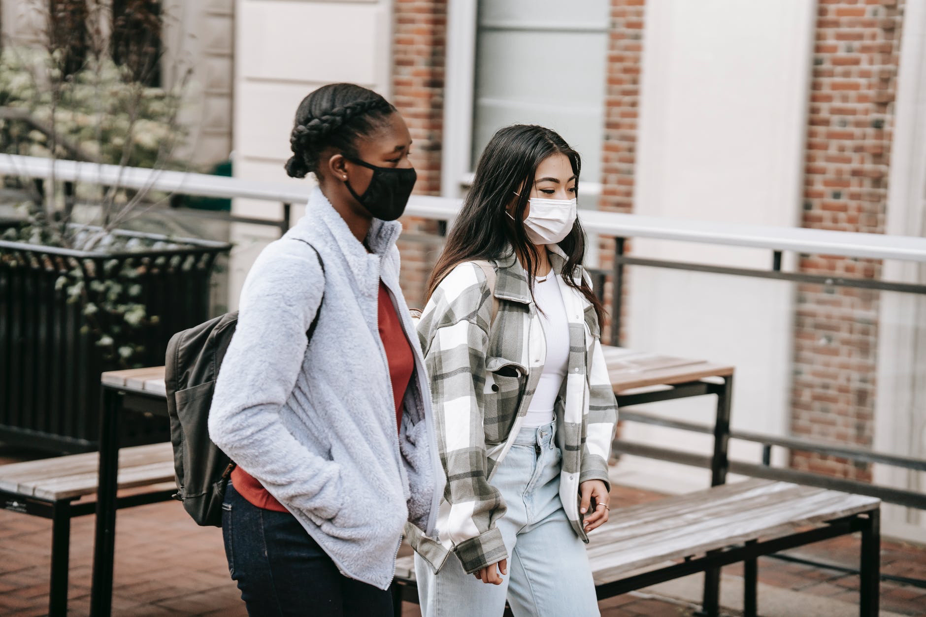 Masked students walking with backpacks.
