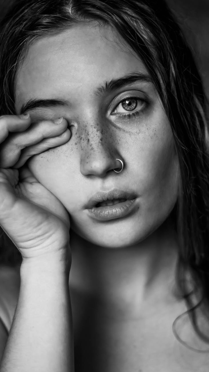 Woman with nose ring rubbing eye.