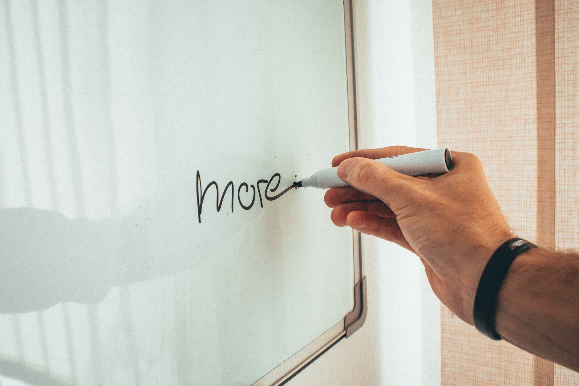 More written on whiteboard by hand holding black marker