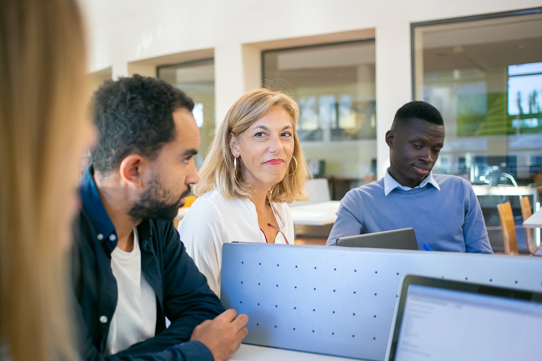Latinx, white, and black male, female, and male adults seated in classroom.