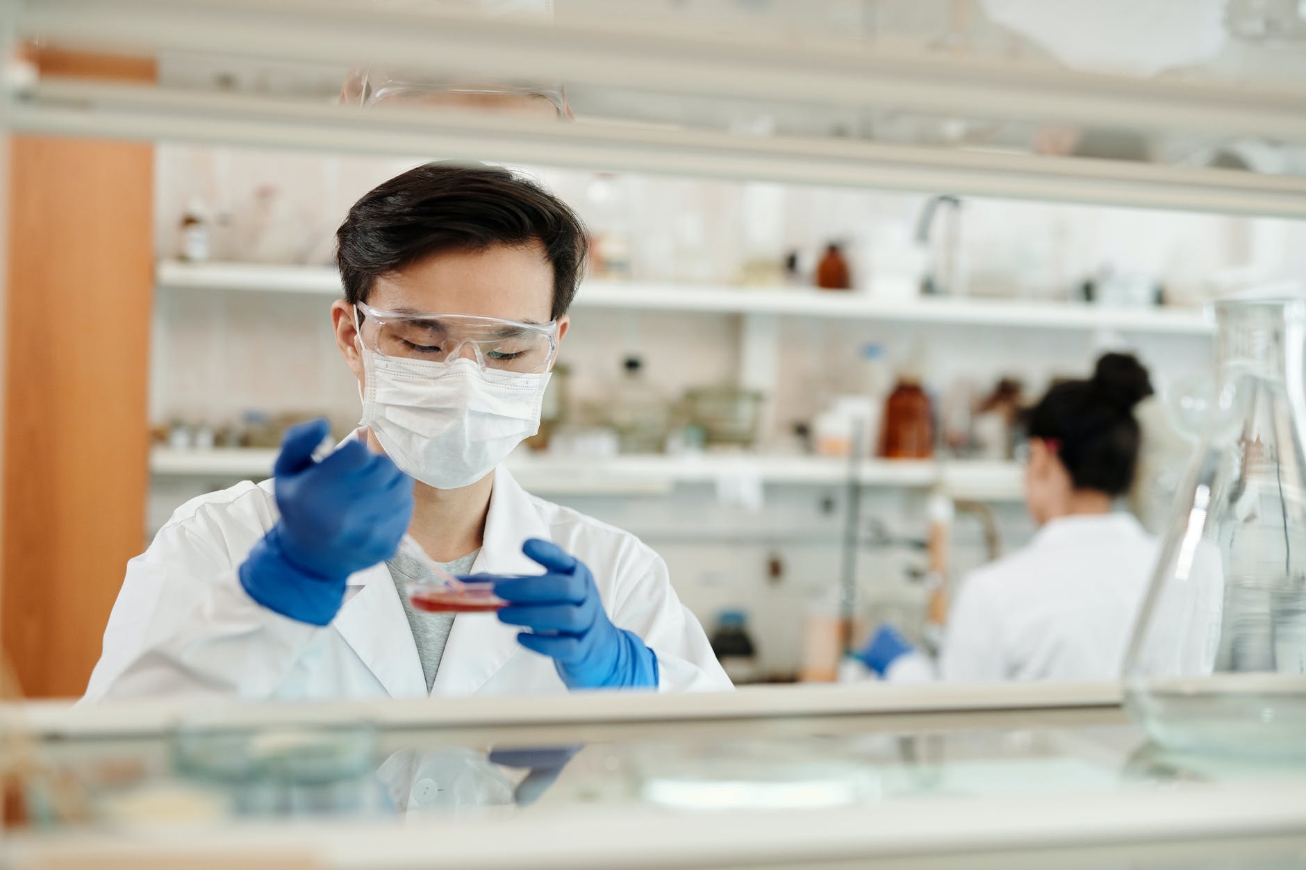 Scientist wearing mask and lab coat working in the lab