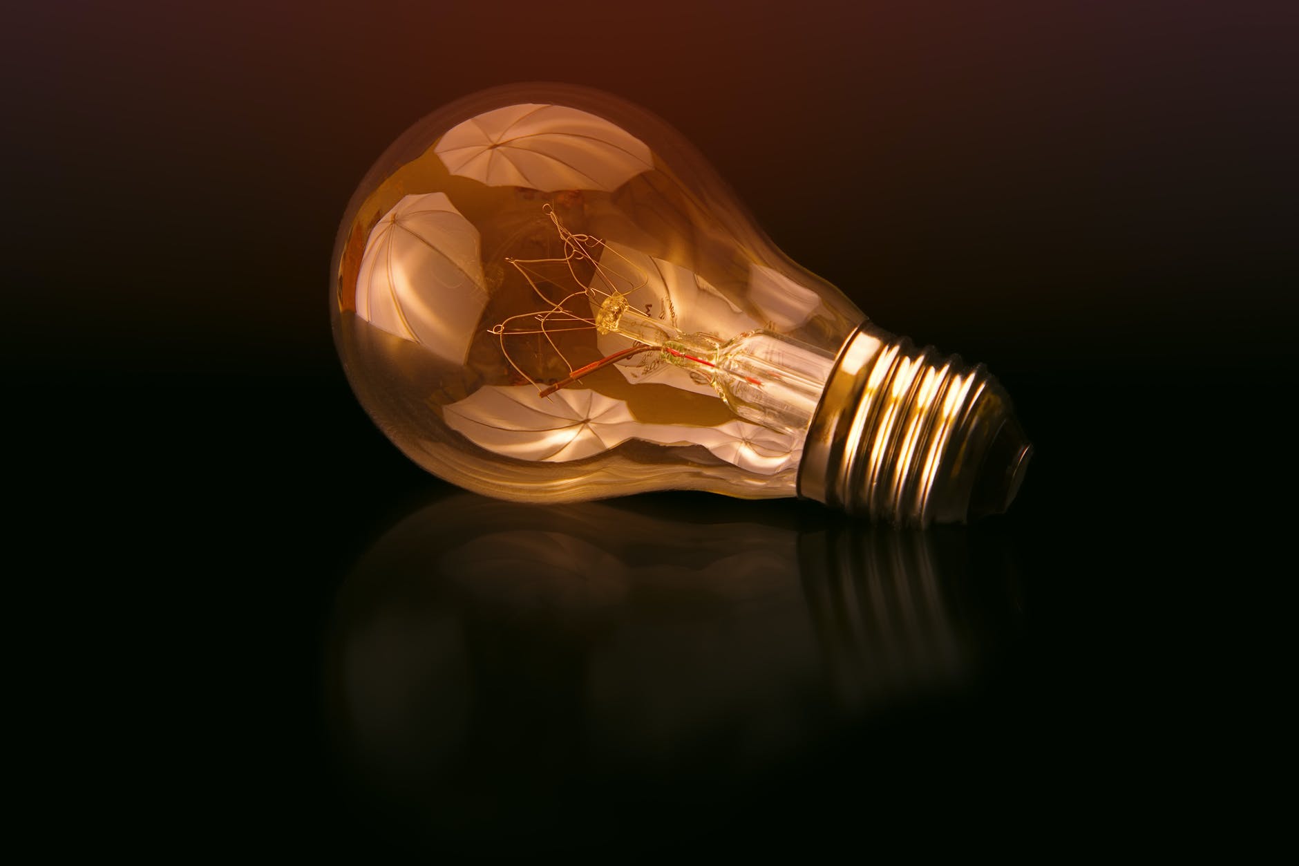 Dark background and lightbulb with bright orange outlines.