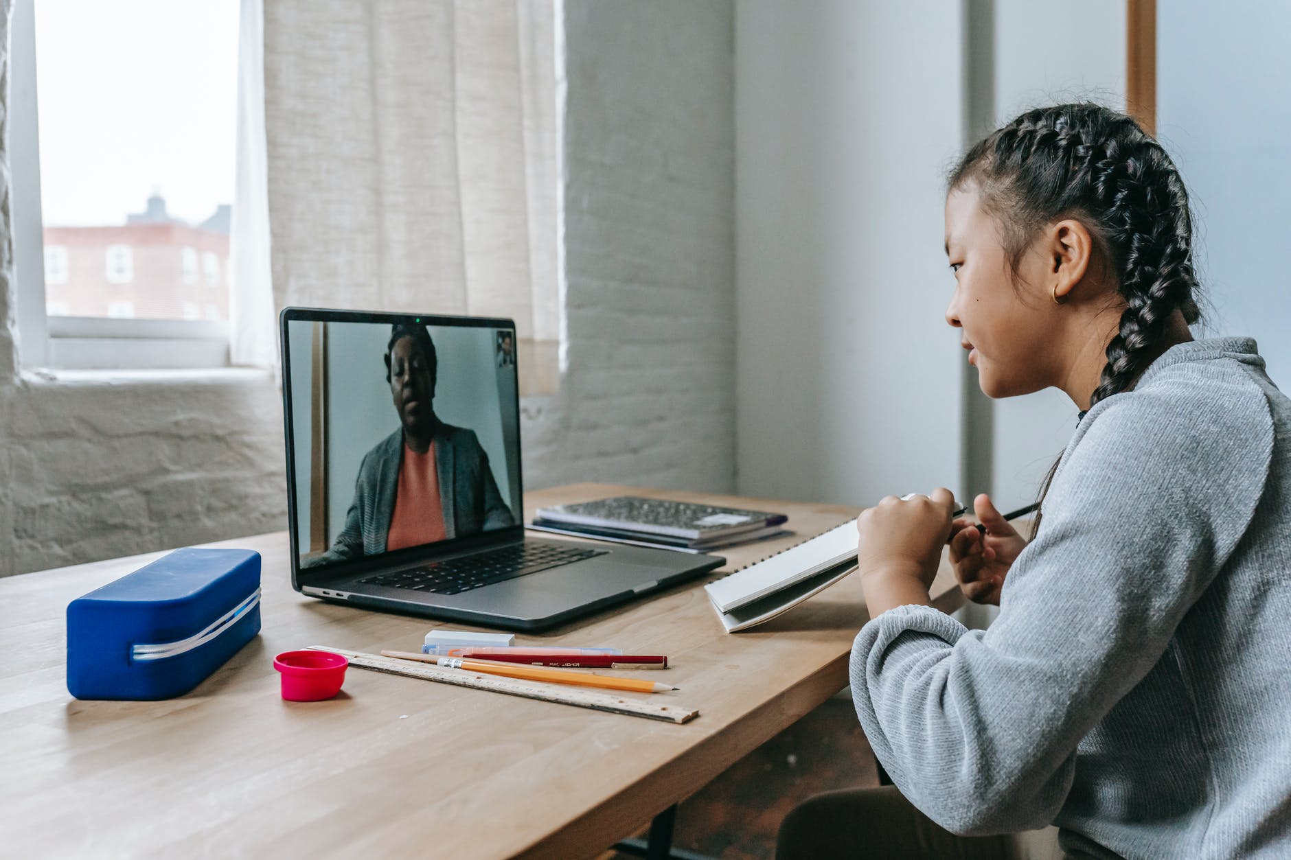 Brown woman listening to video session on laptop.