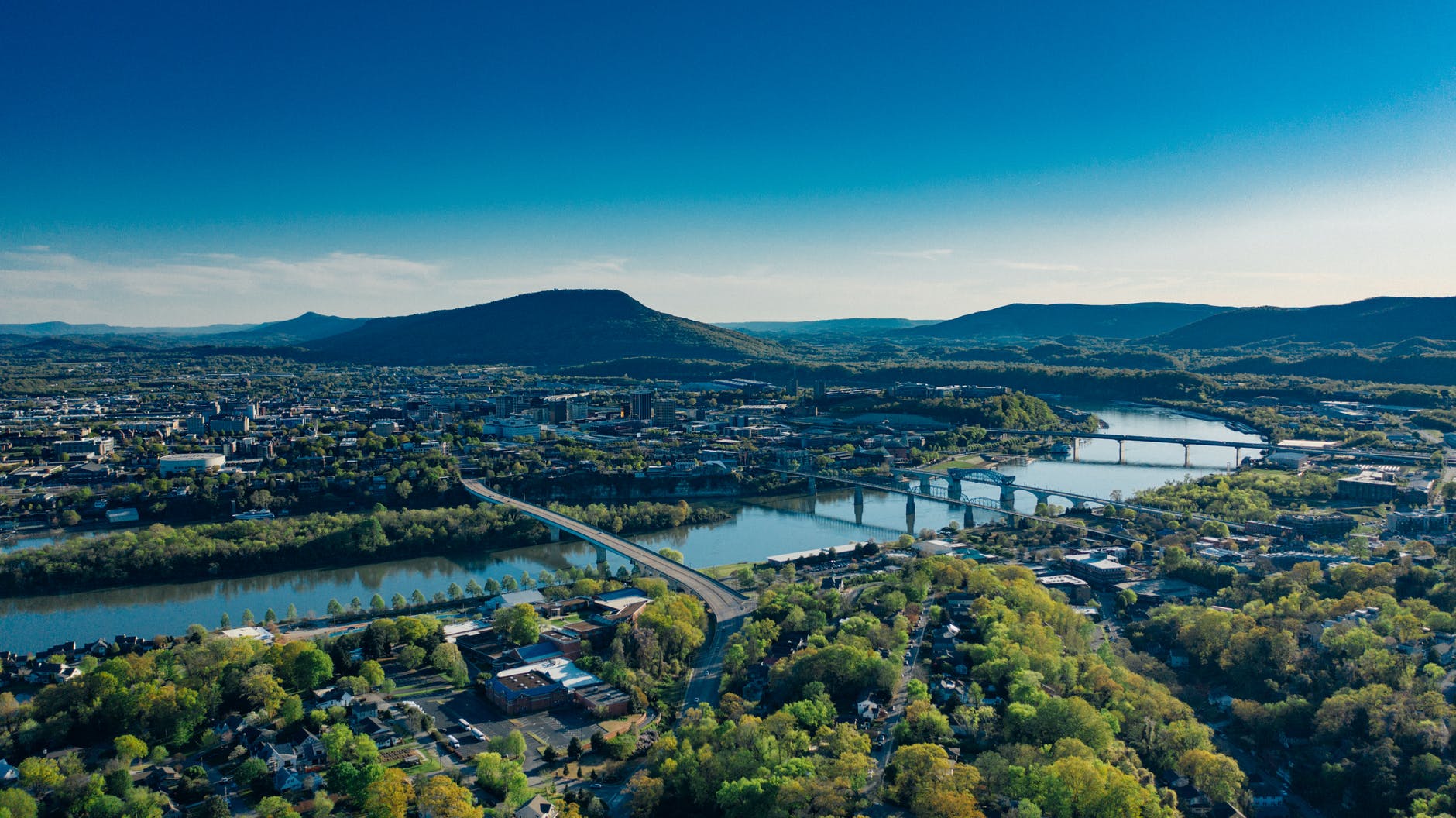 Image of bridges and a river. Mountains in the distance.