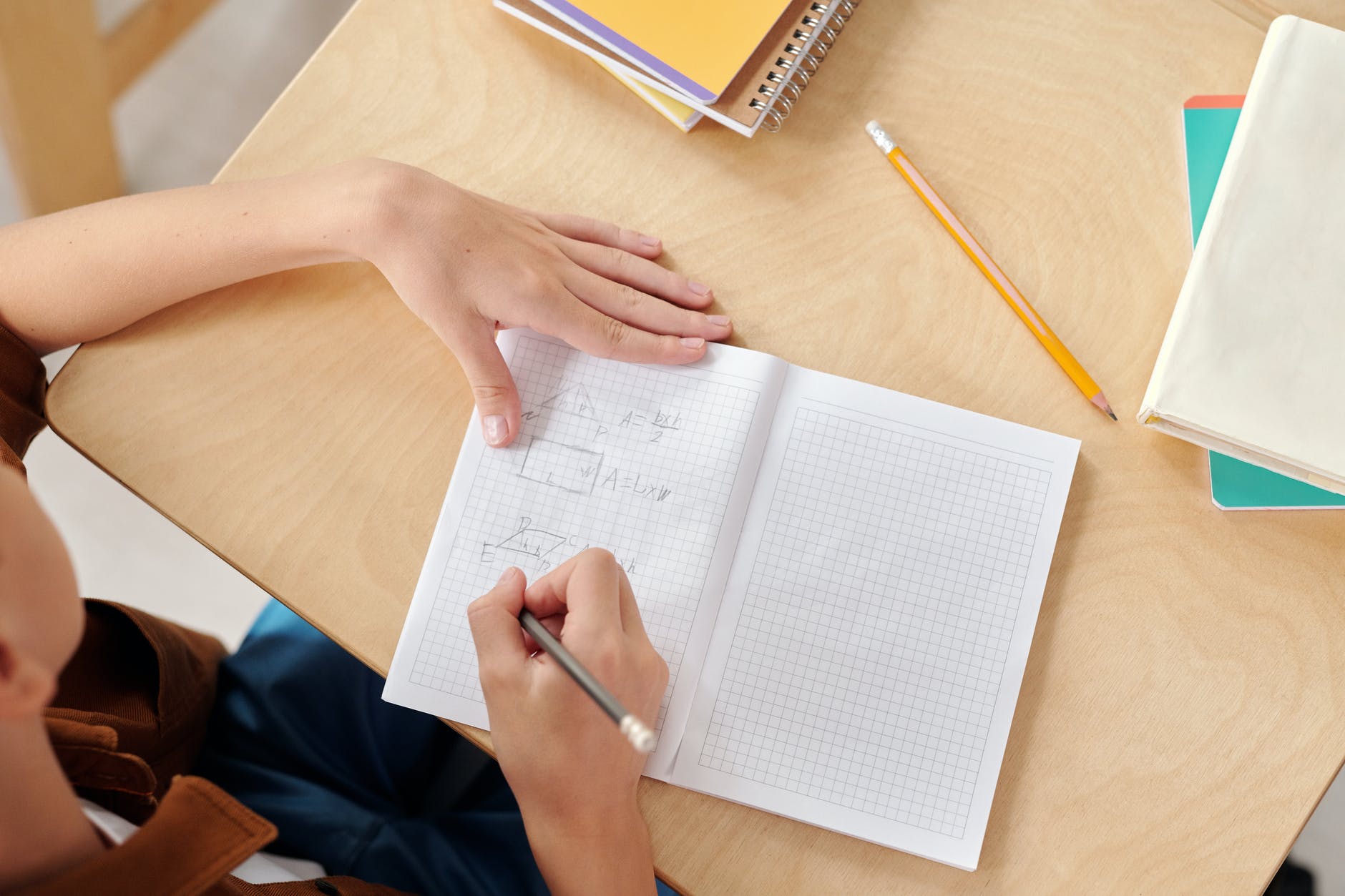Notebook with hand holding pencil.