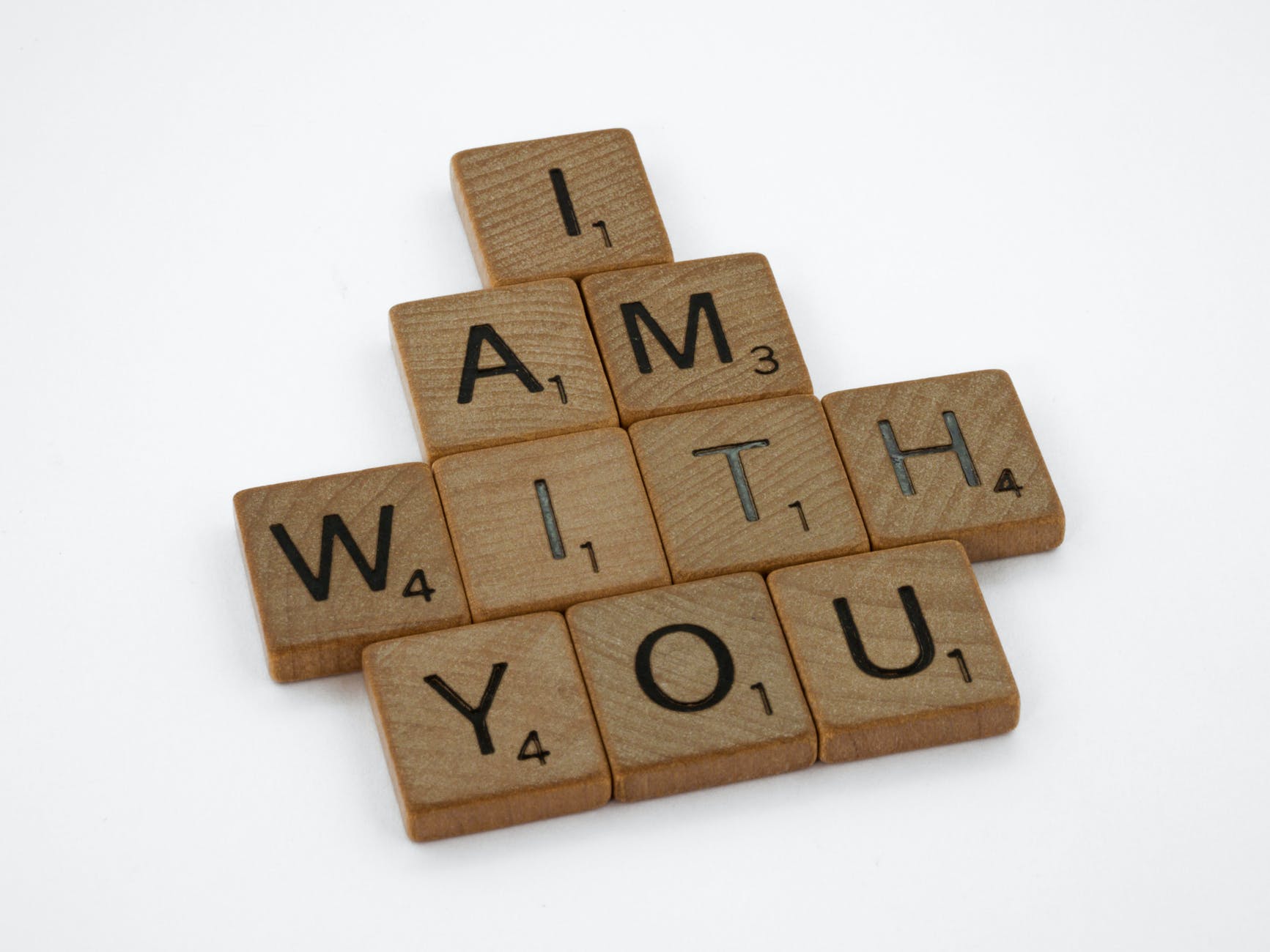Scrabble pieces spelling "I am with you" on four rows.