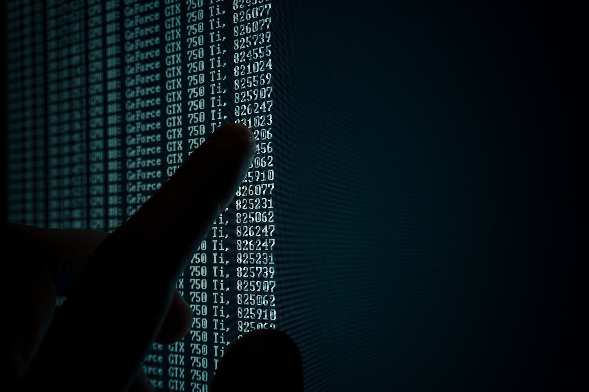 Black computer screen with green text. Finger is pointing to a number in the list.