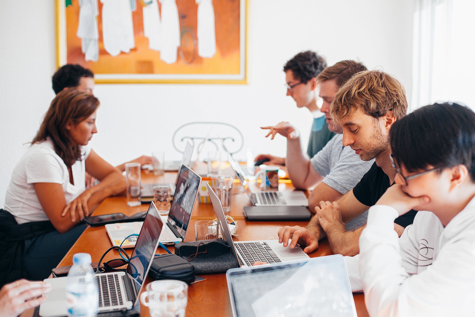 People seated at table focused on computer work.