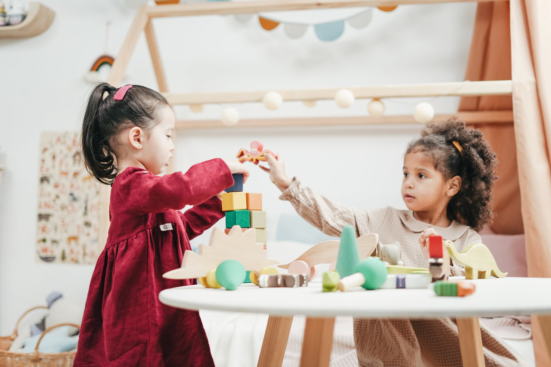 Two children playing at a table with blocks.
