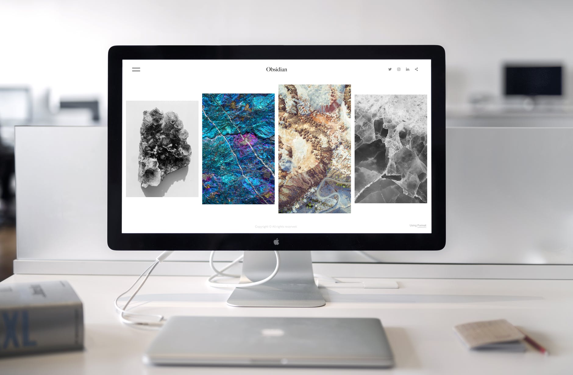 Monitor connected to Mac laptop. On the screen there are four images of obsidian from a website.