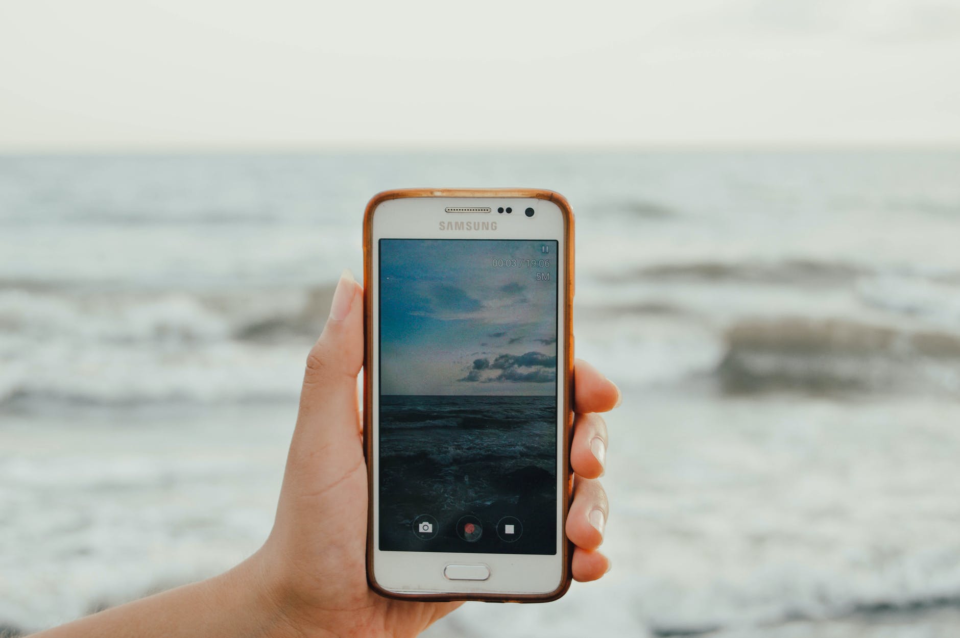 Cell phone capturing waves and clouds.