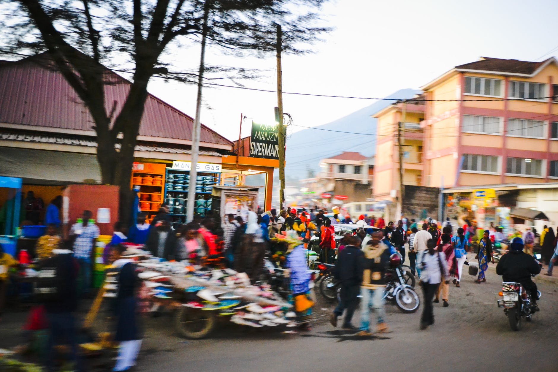 Busy street in Africa. People and motorcycles can be seen.