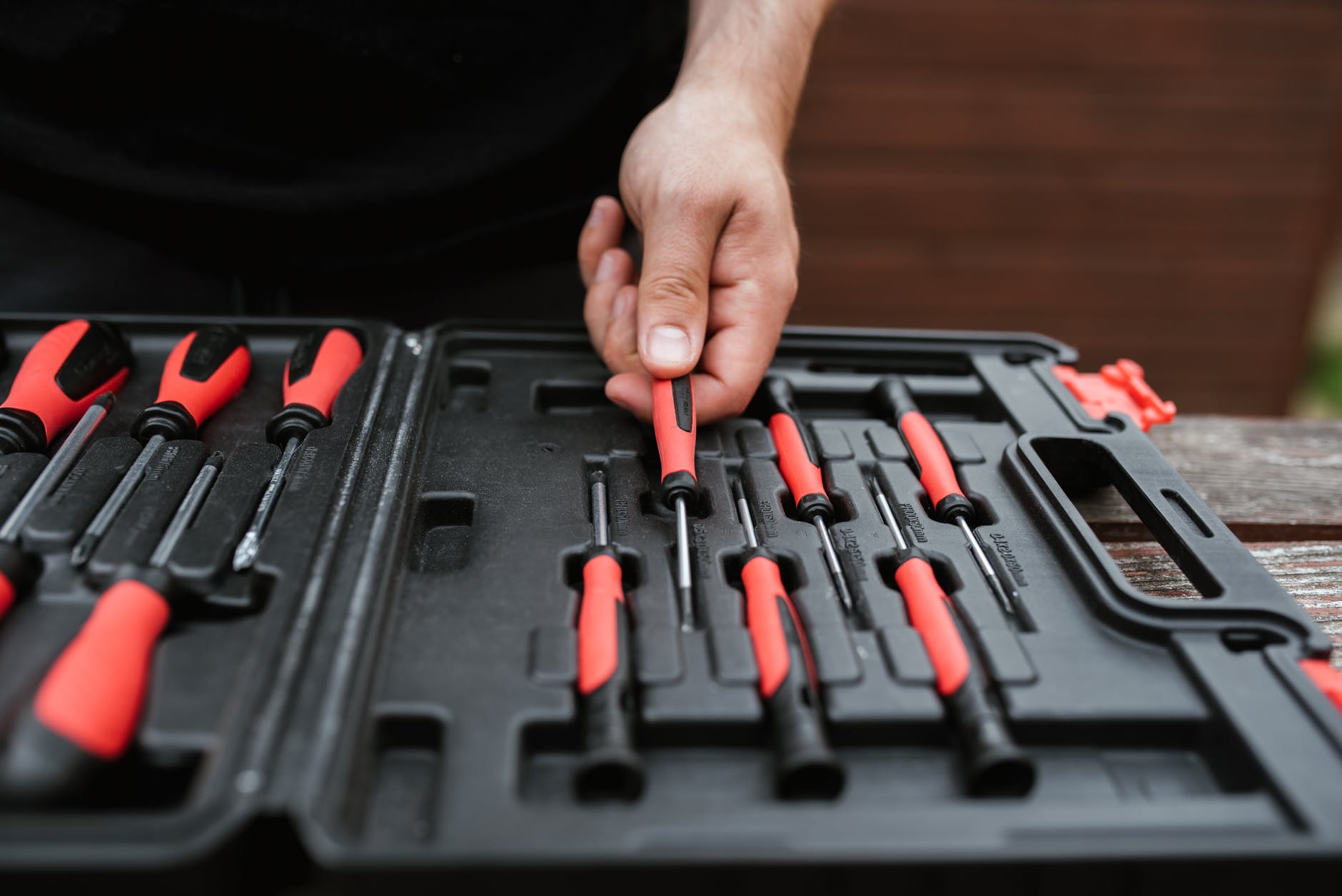 Toolbox with tools with red and black plastic grips. The toolbox is a plastic case with holders for a series of screwdrivers.