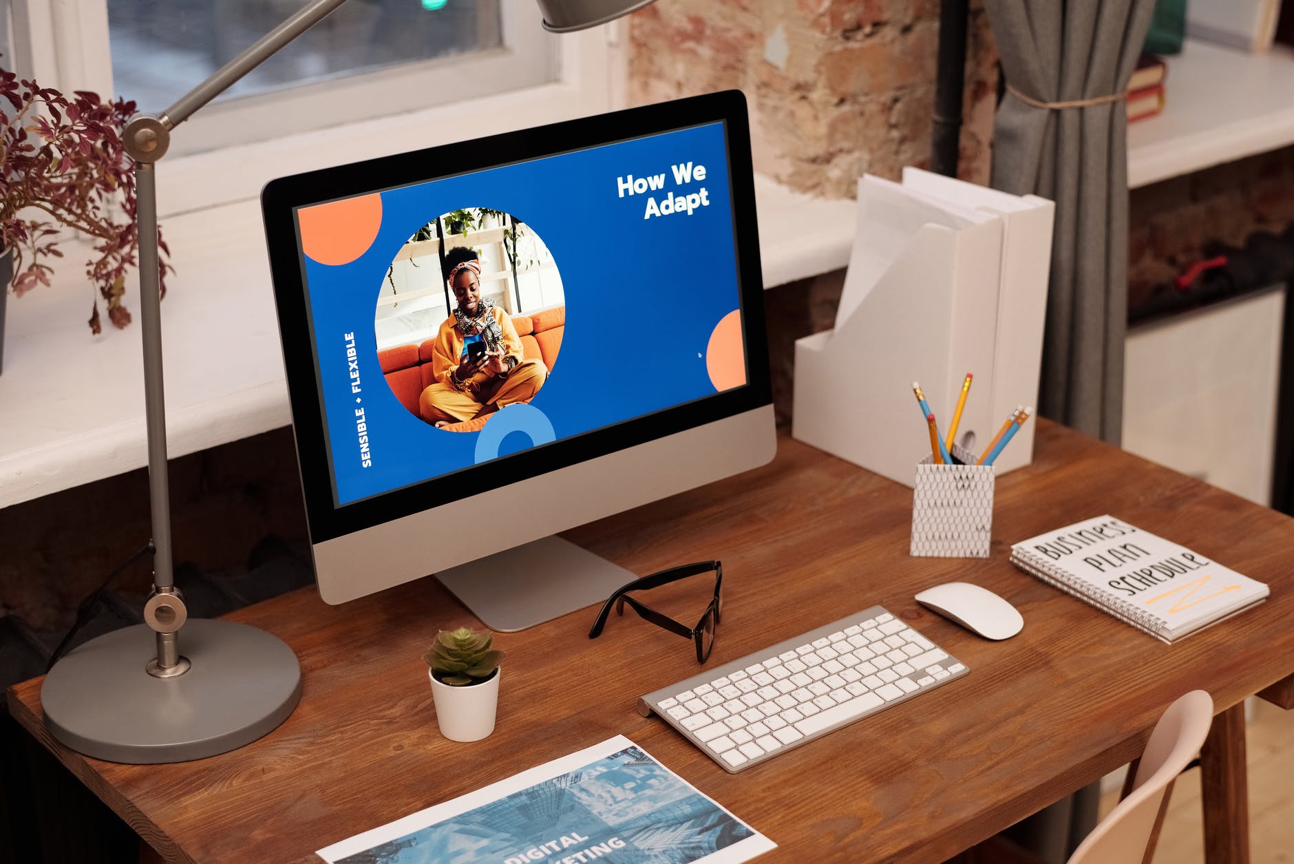 Table with keyboard and desktop with slide with text "How We Adapt"
