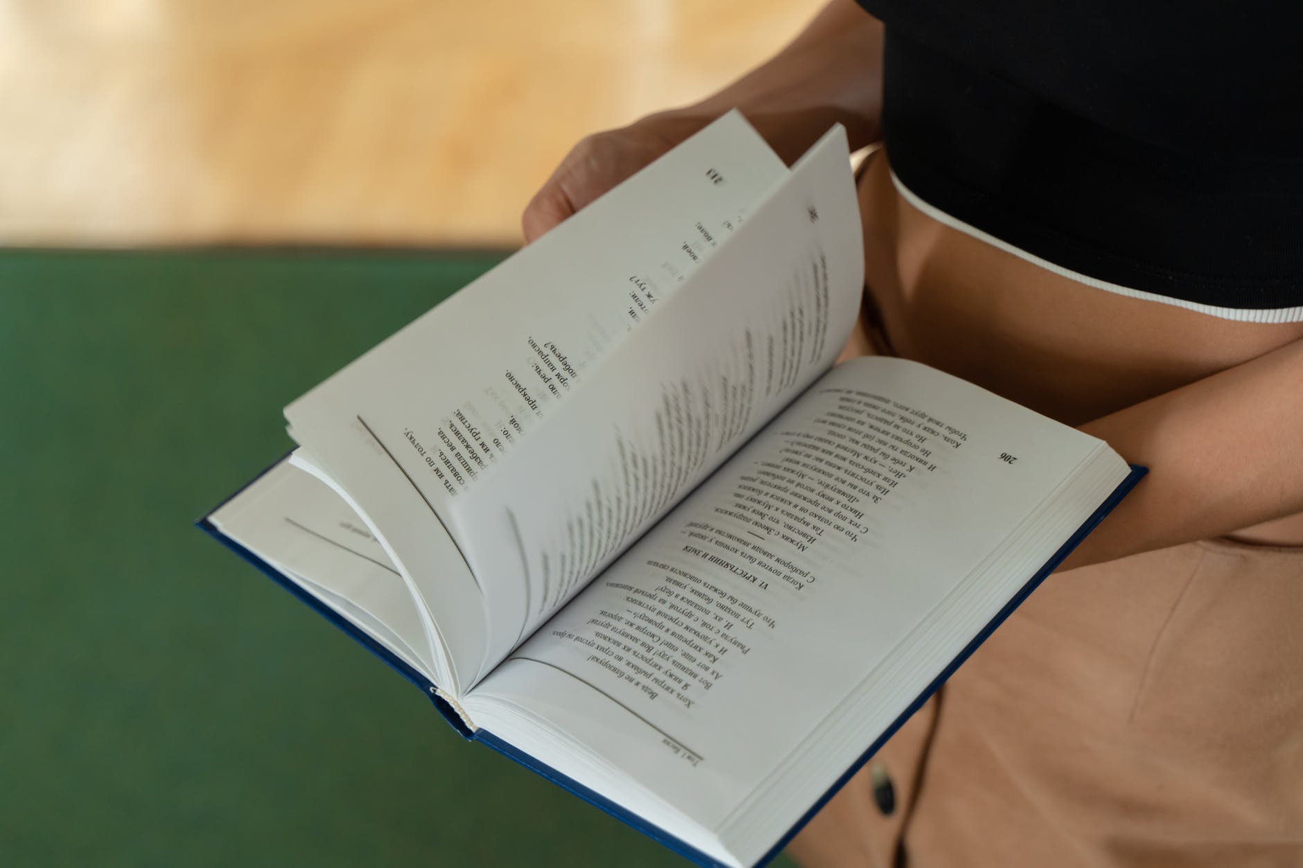 Hands holding open textbook