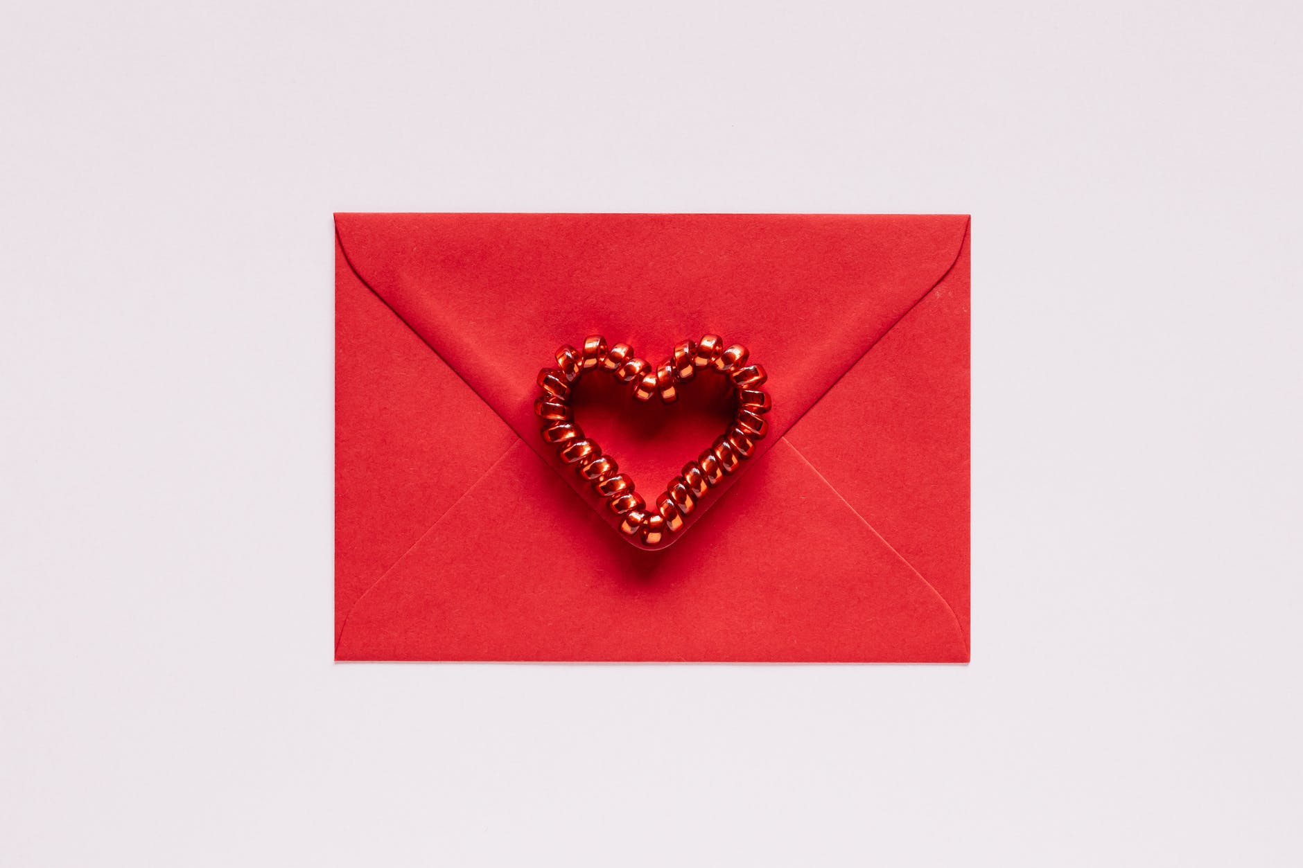 Red envelope with red beads forming heart shape