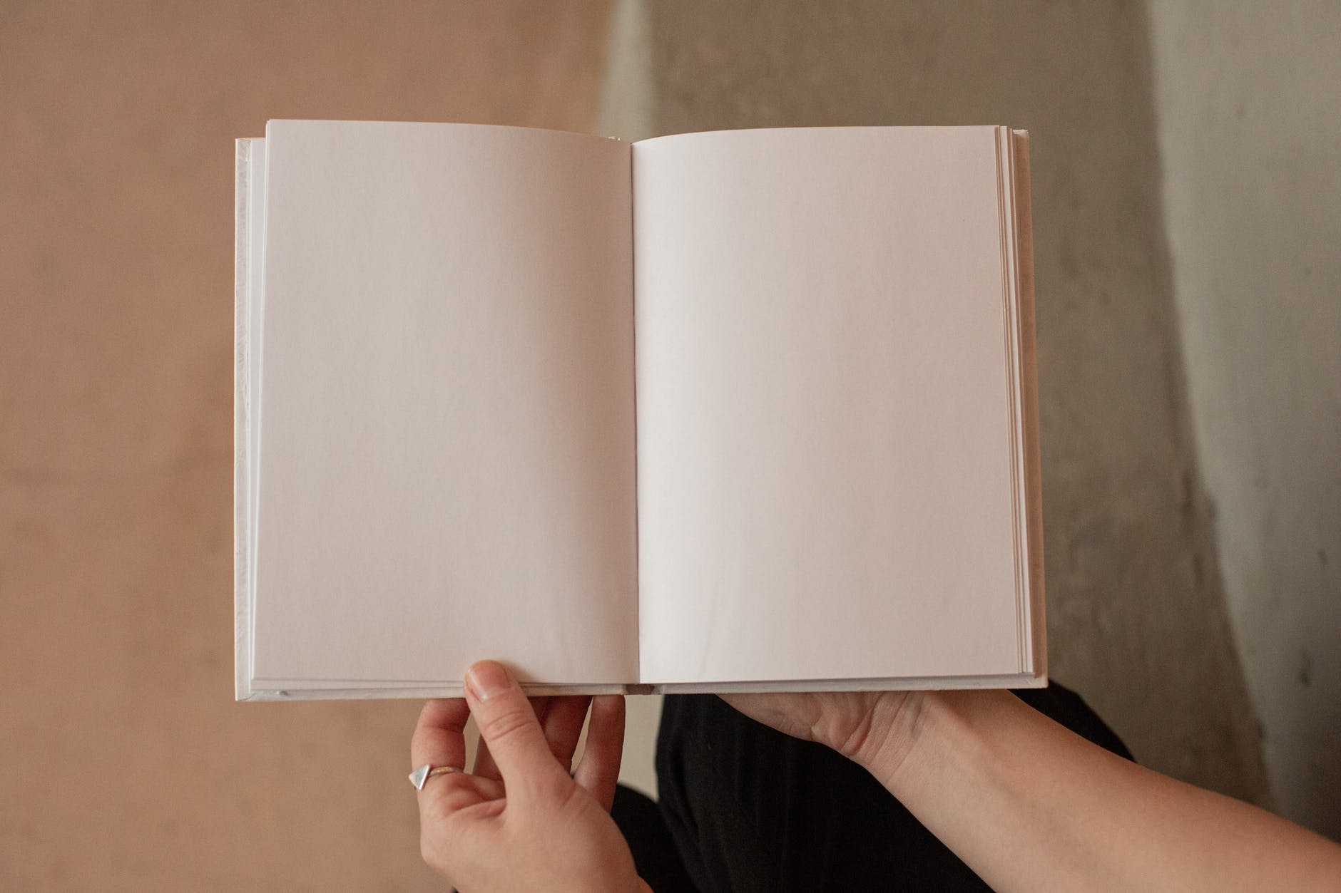 Hands holding open book with blank pages