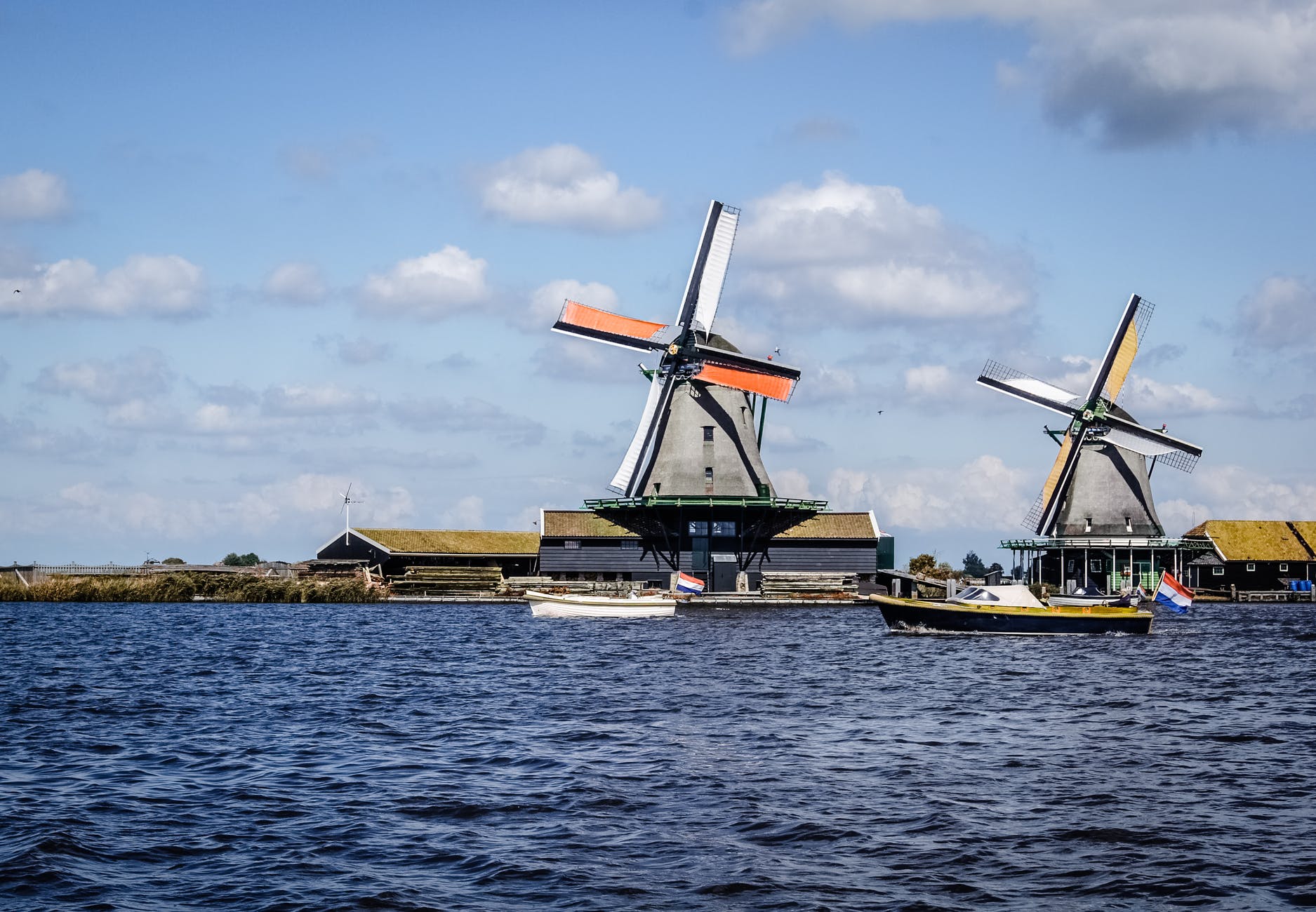 two white rice mills and water and boats.