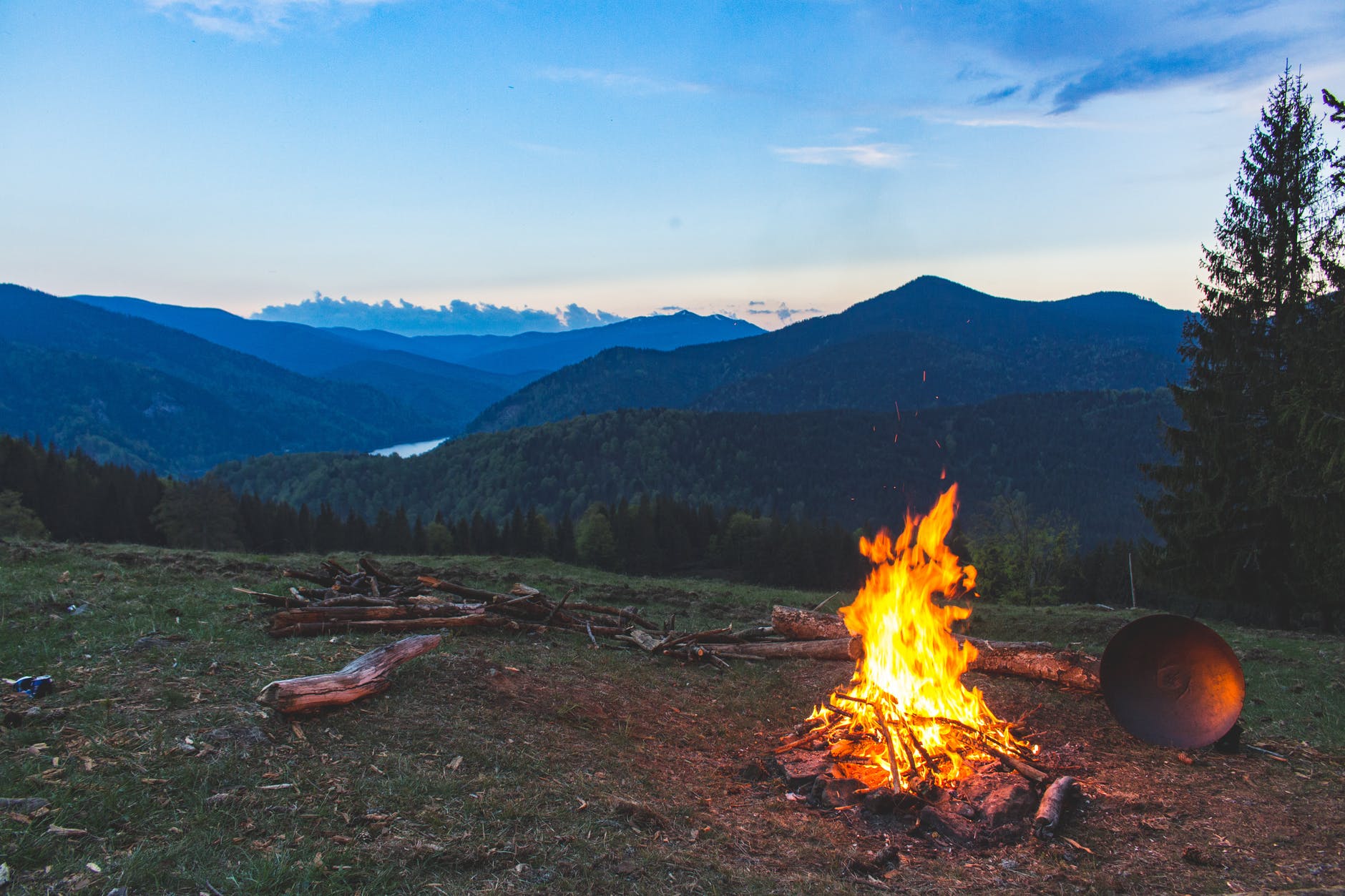campfire and logs, mountains in the distance