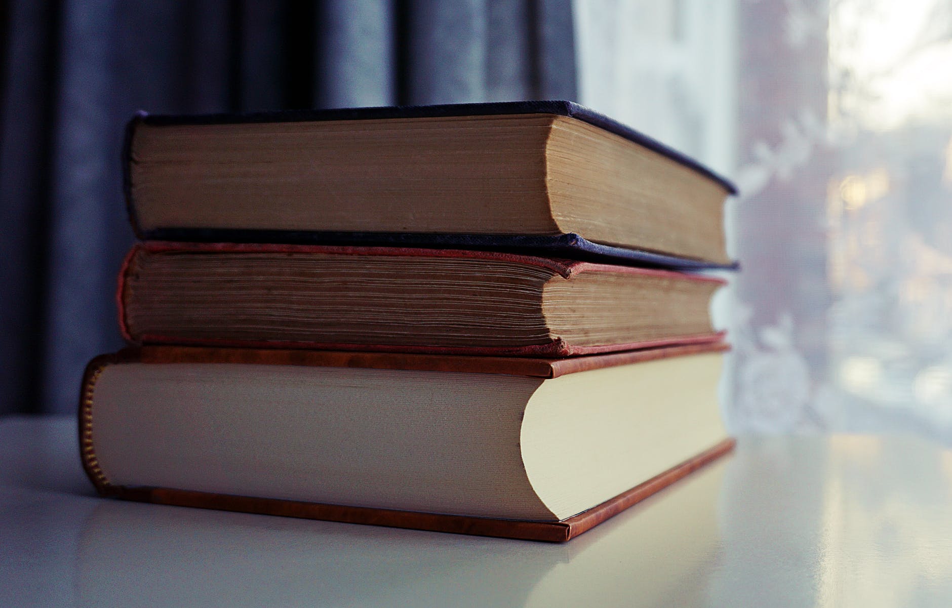 Stack of three thick books.