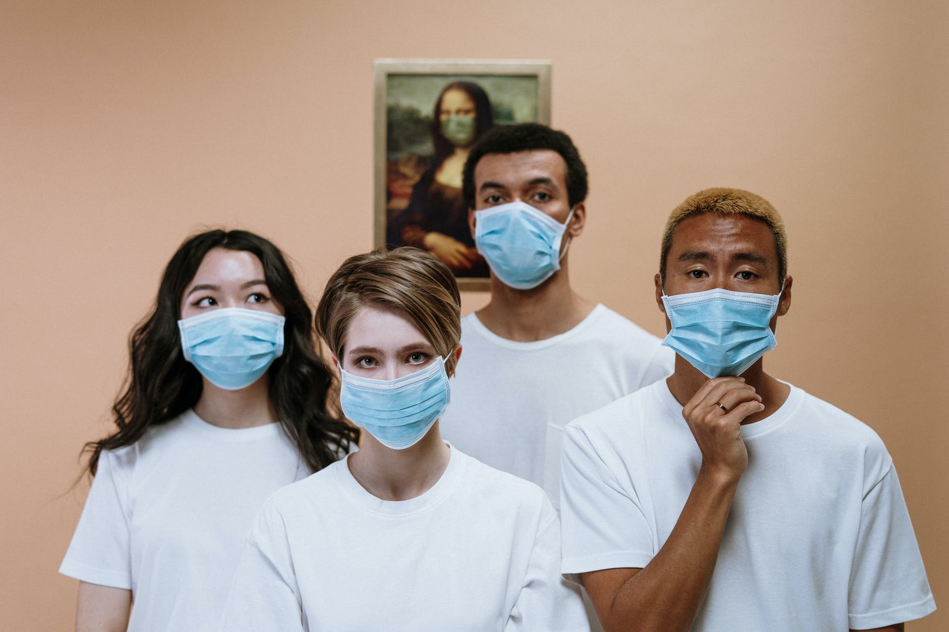 four nurses wearing surgical masks and white t-shirts