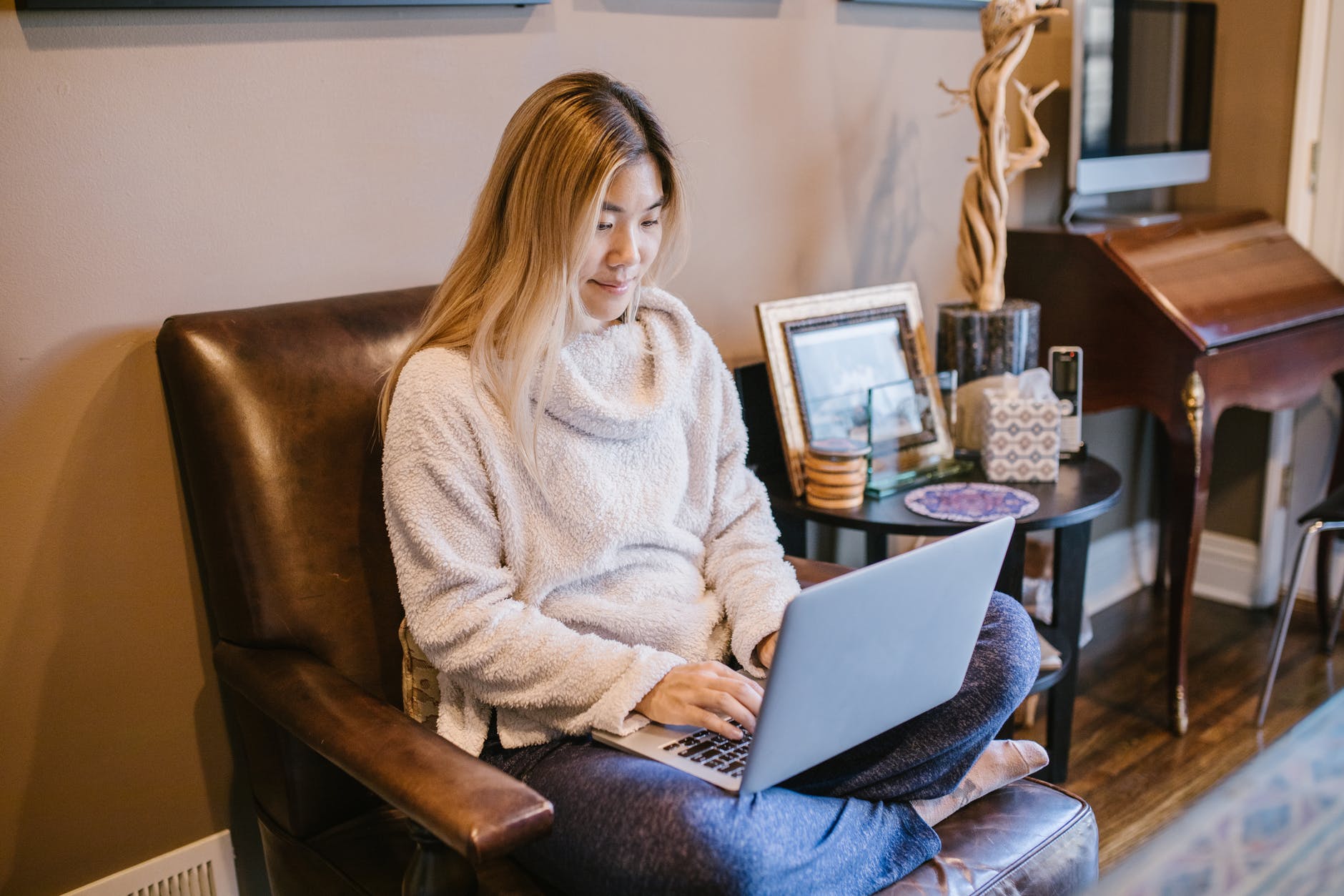 Woman seated and typing on laptop