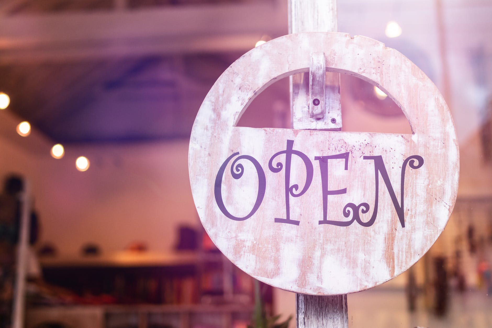 Window with round pink sign with word "OPEN" in purple.