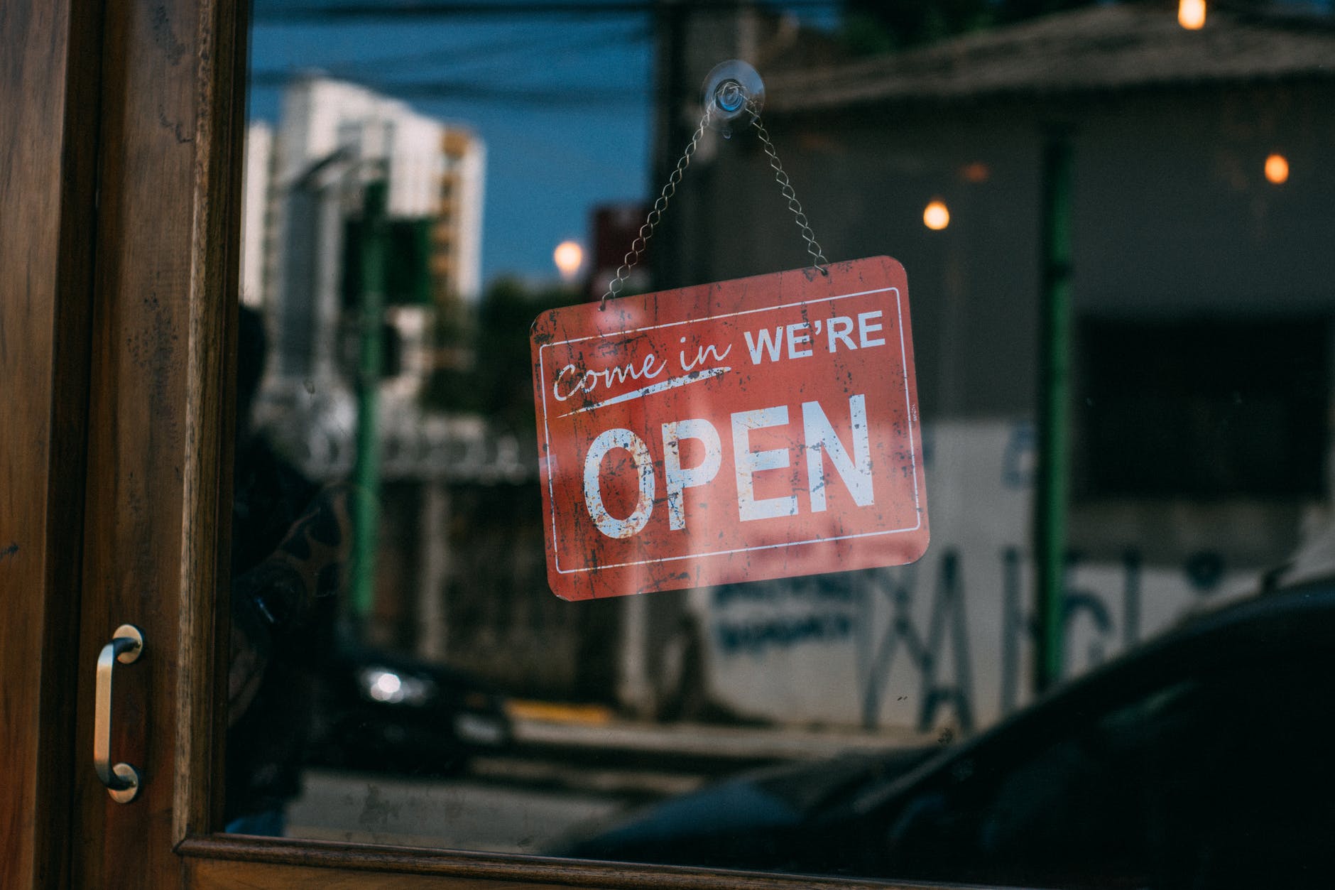 Window with red sign: "Come in We Are OPEN"