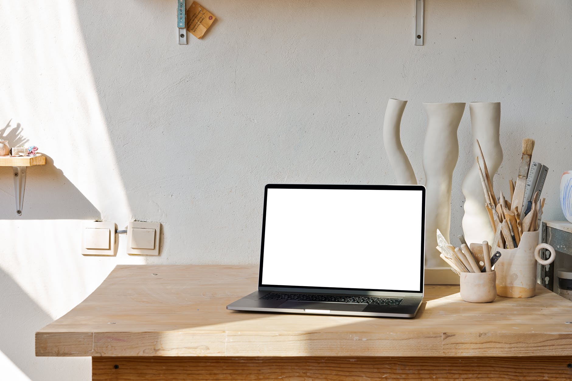 Laptop with white screen on art table.