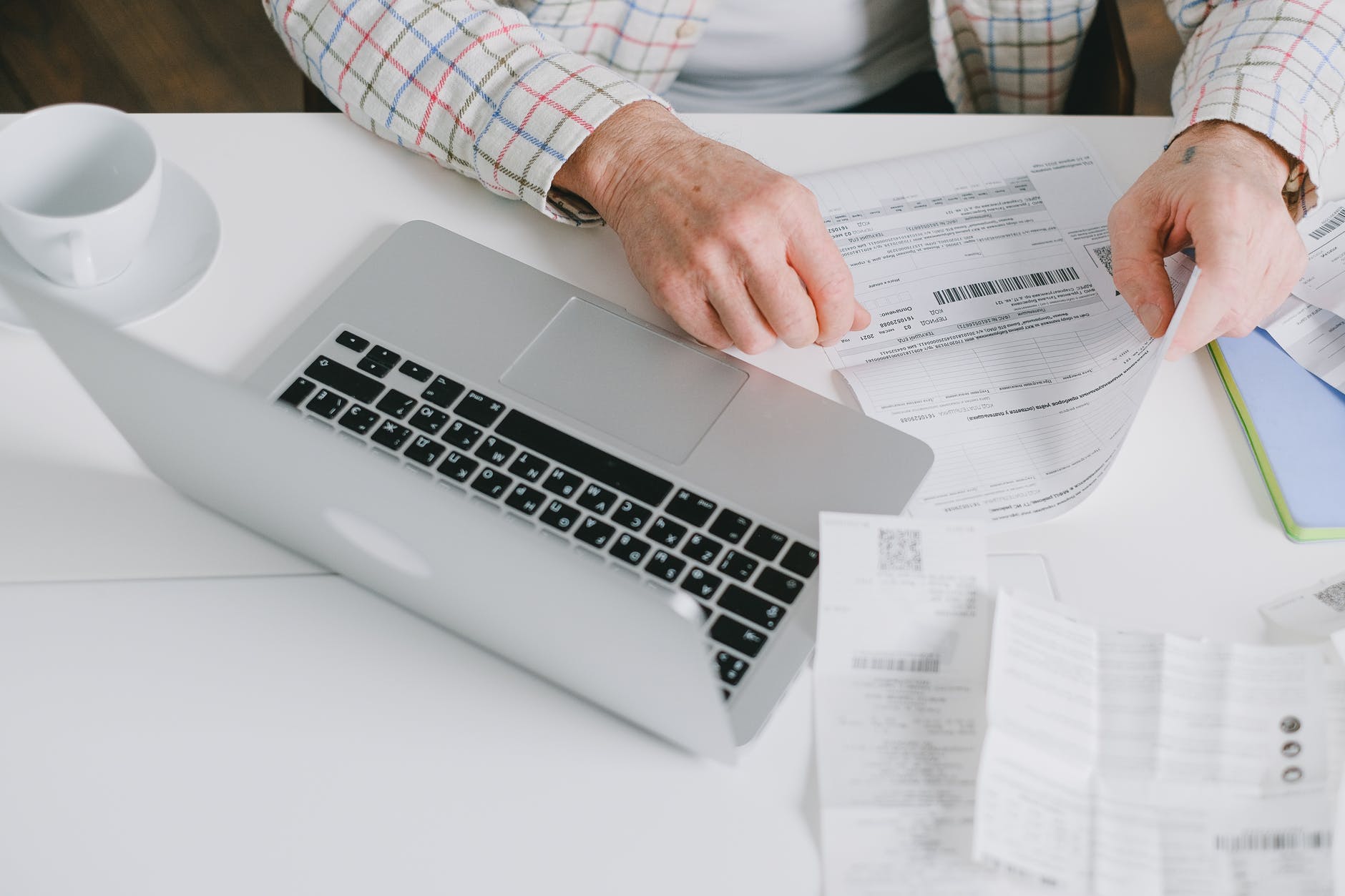open laptop and hands with document with barcode