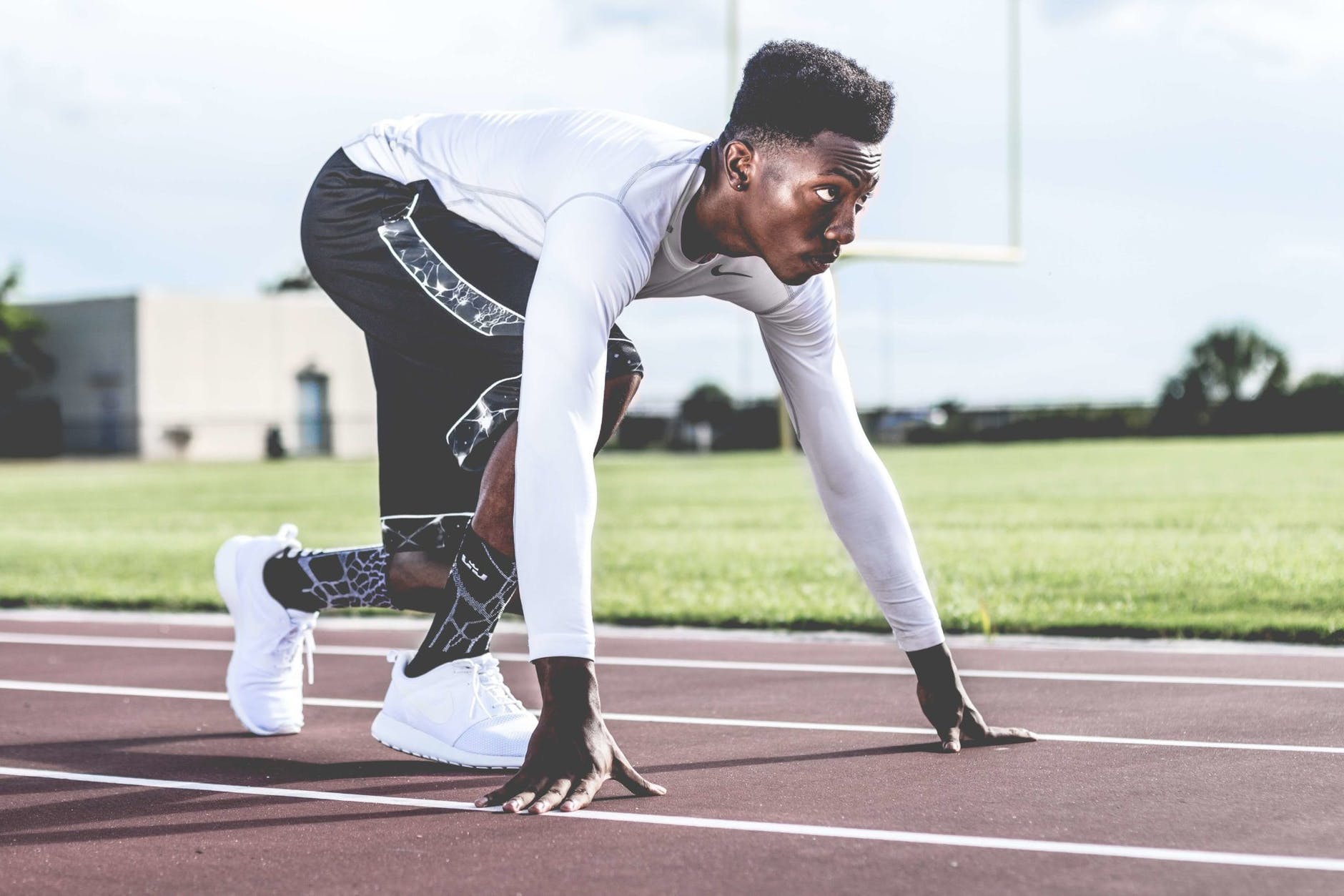 Black sprinter on track preparing to run