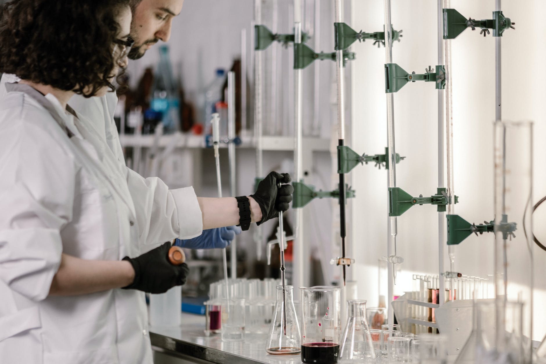 Man and woman working with columns and lab glassware in chemistry lab