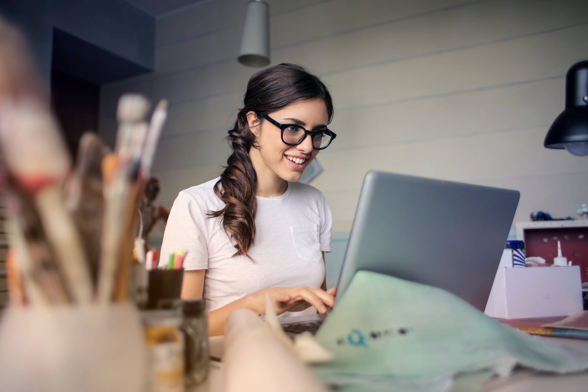 Woman with glasses working at laptop