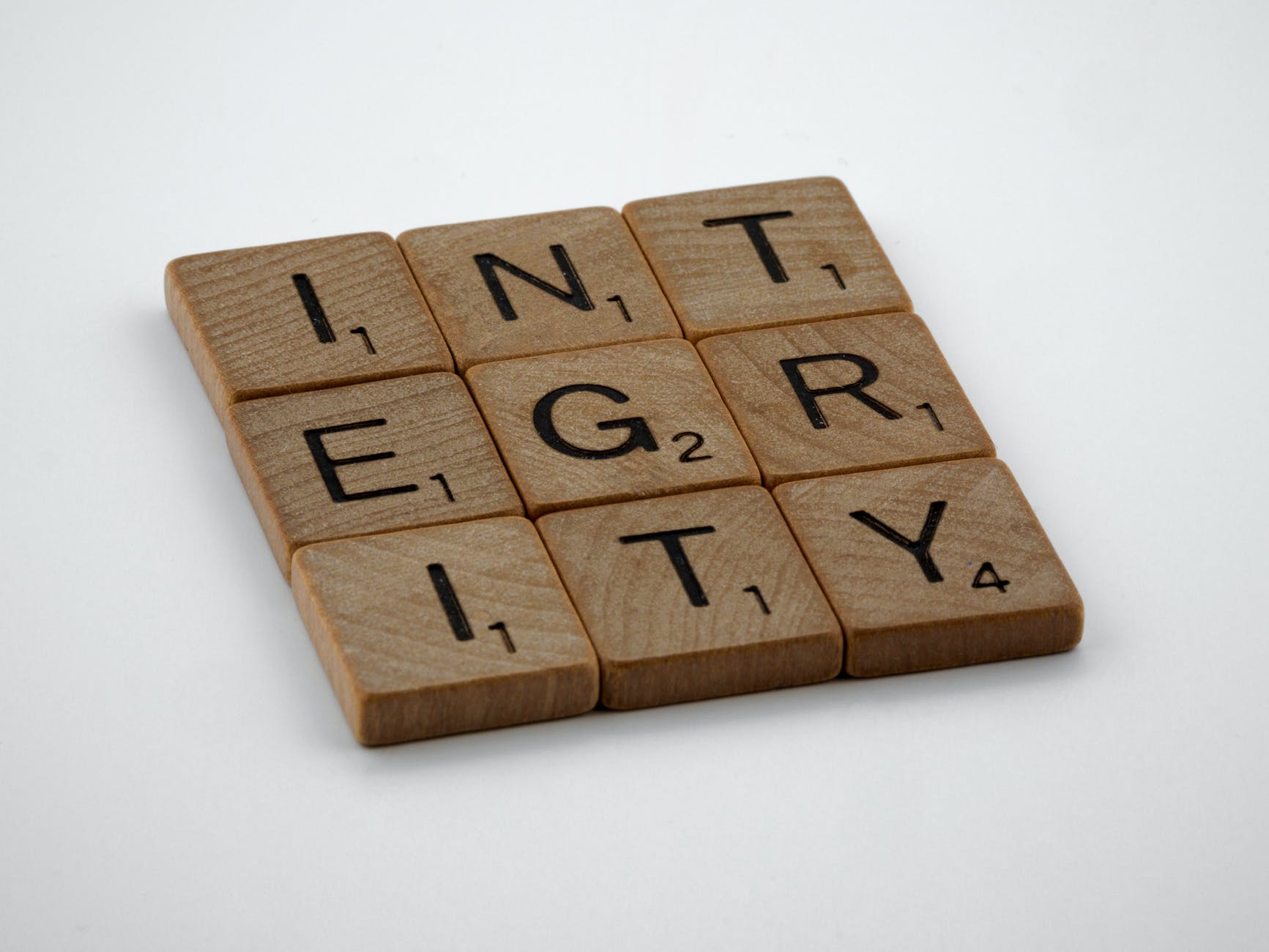 three by tree Scrabble chips spelling "INTEGRITY"
