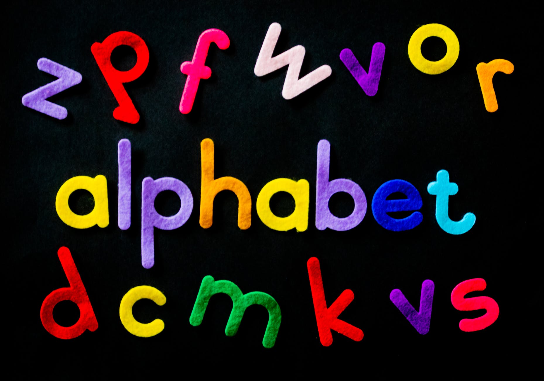 black background with colorful lowercase letters. Three rows and the middle row spells alphabet