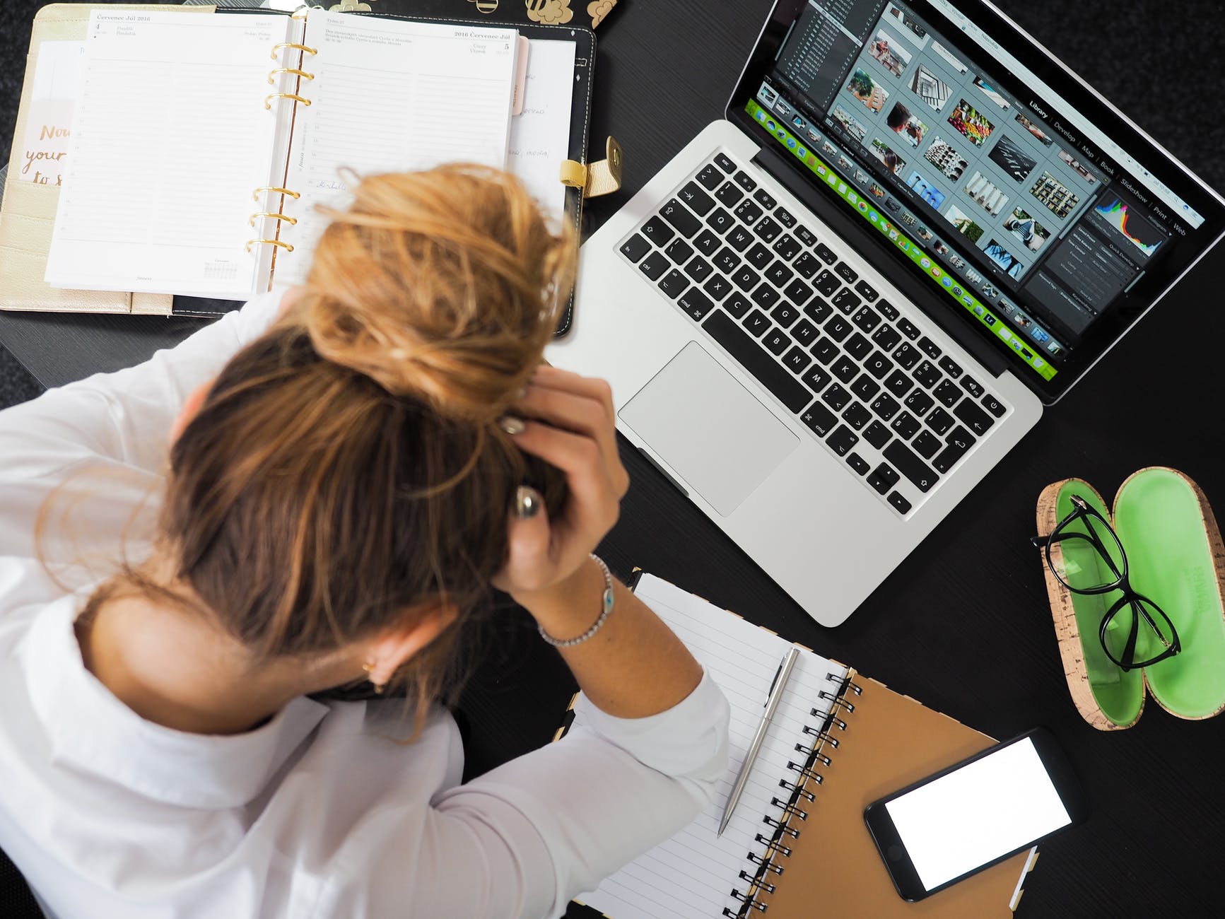 Person at laptop holding long hair