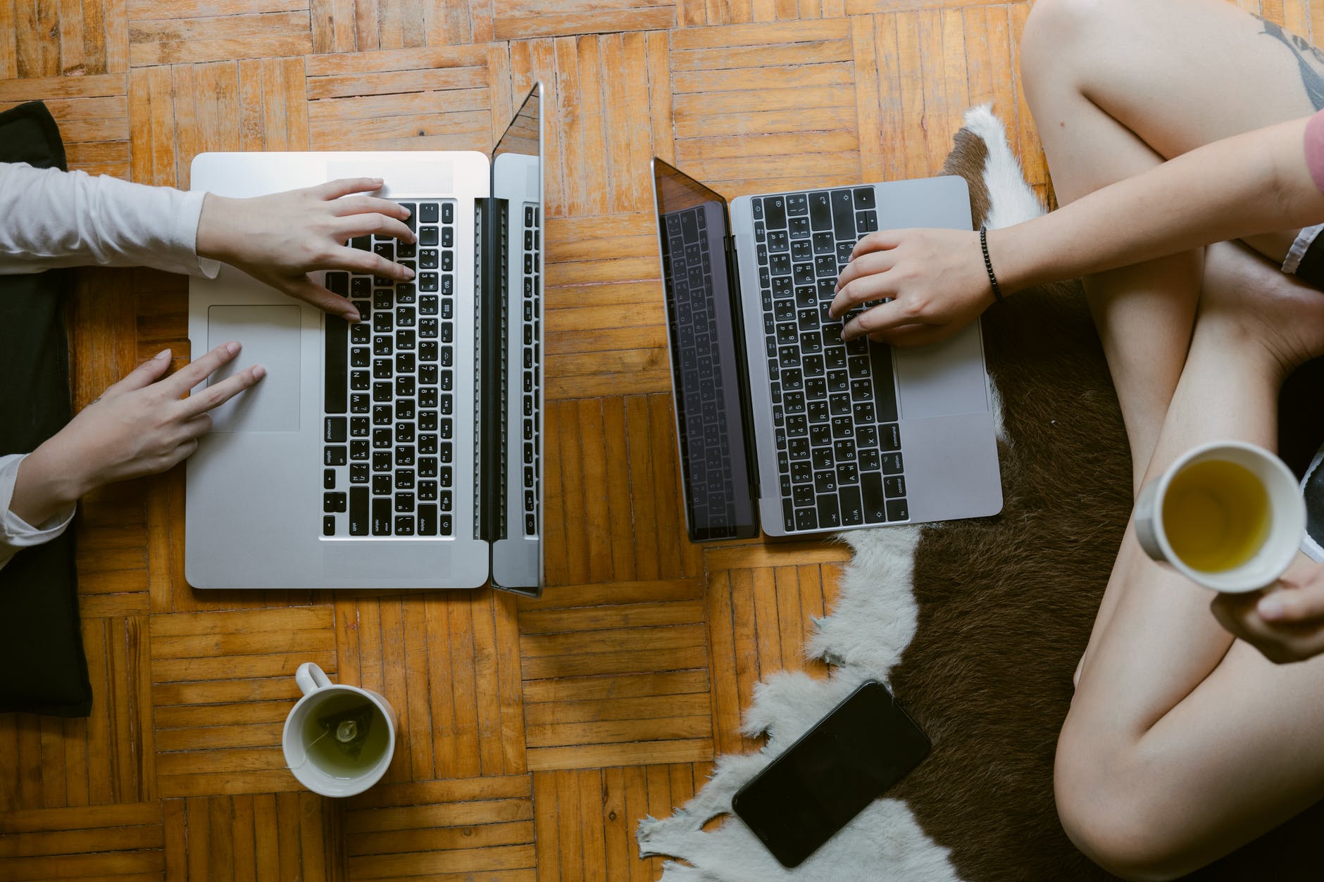 top down view of two open laptops on table.