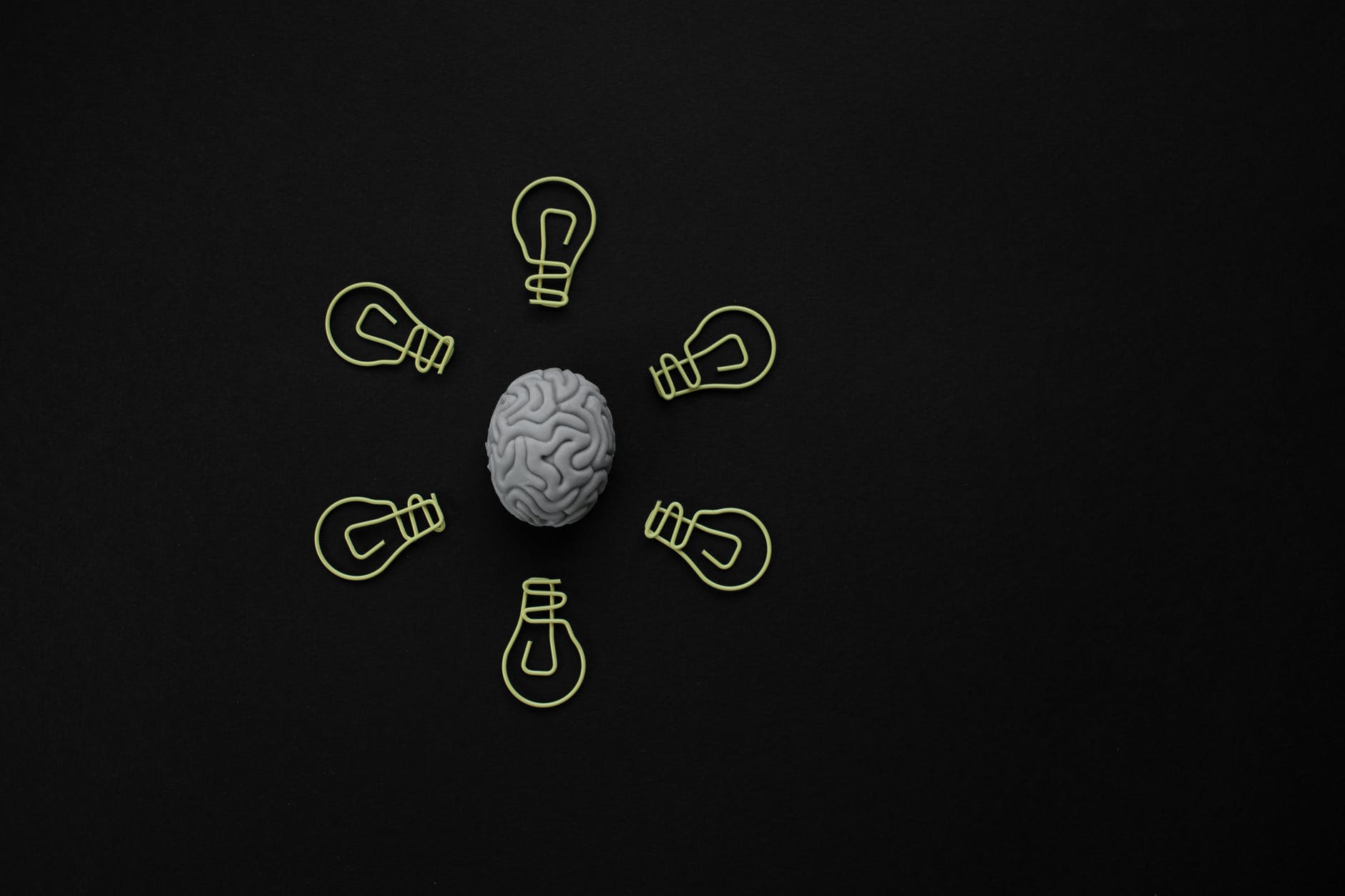 Brain surrounded by illustrations of six light bulbs