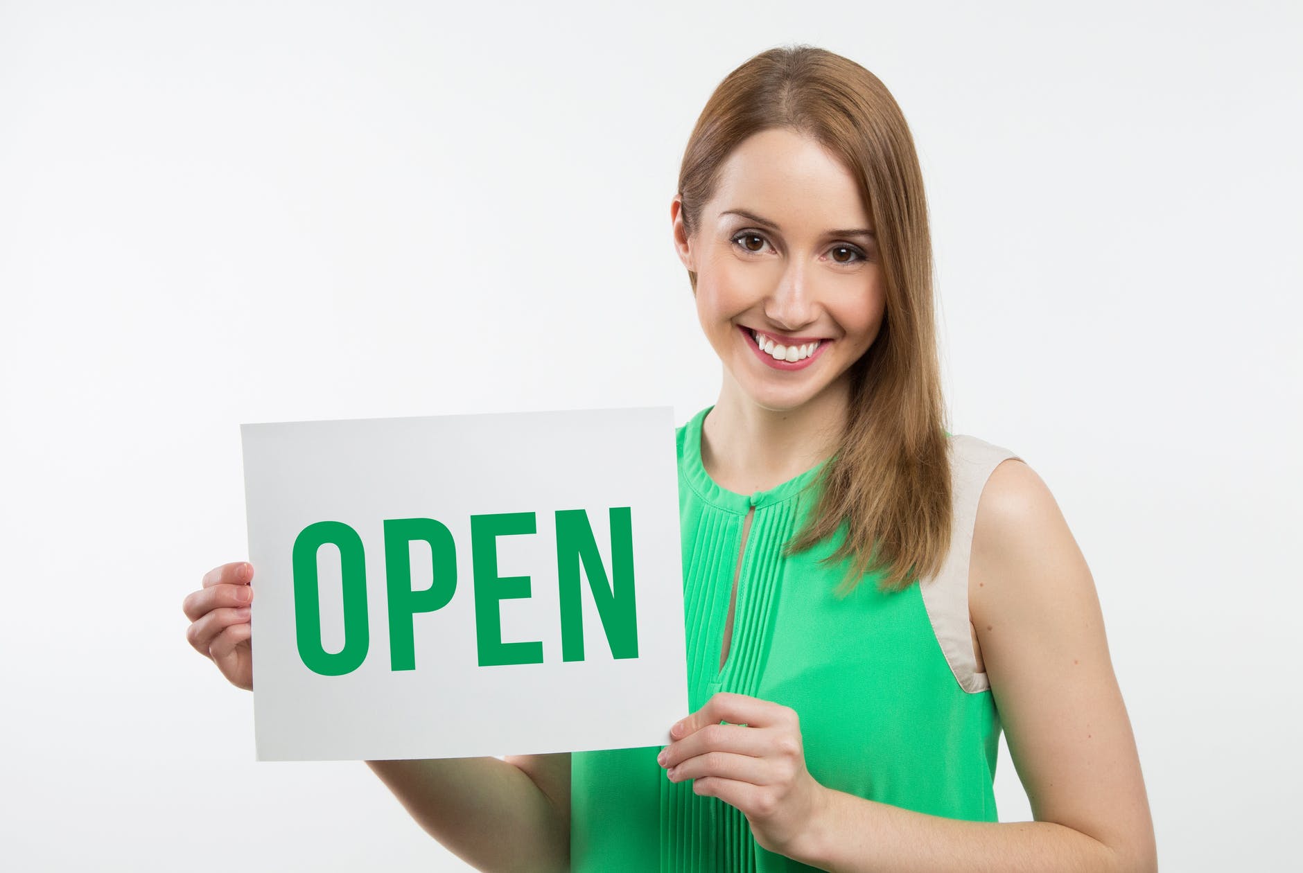 woman holding OPEN sign with green text