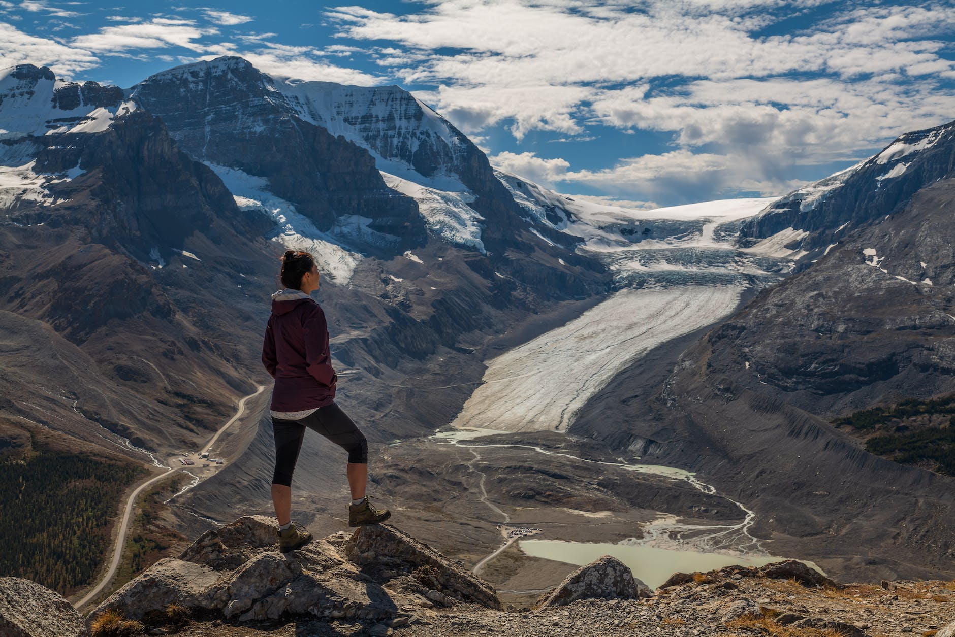 Mountains with snow and person staring at the clouds and mountains