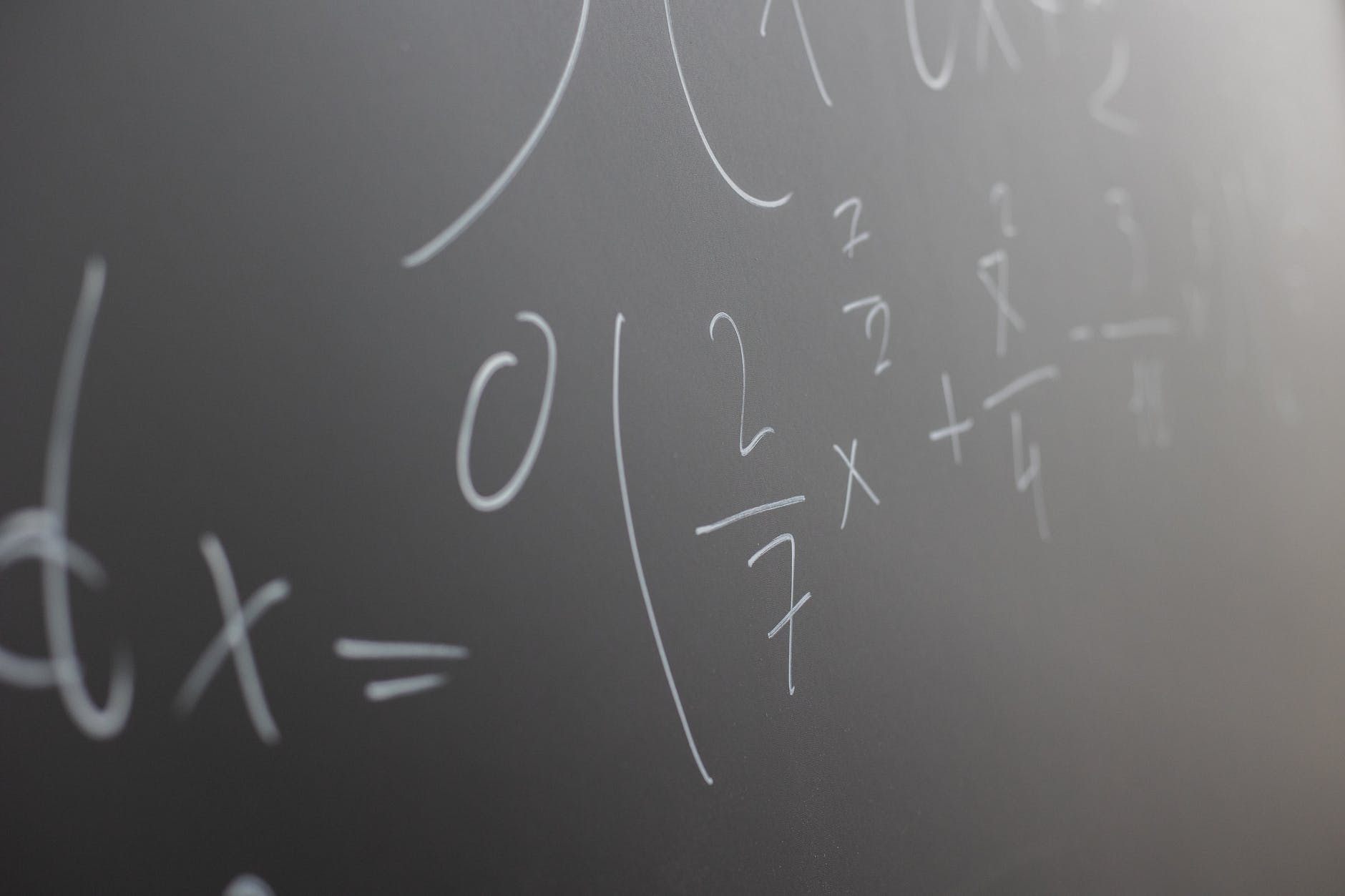 equations written in chalk on chalkboard
