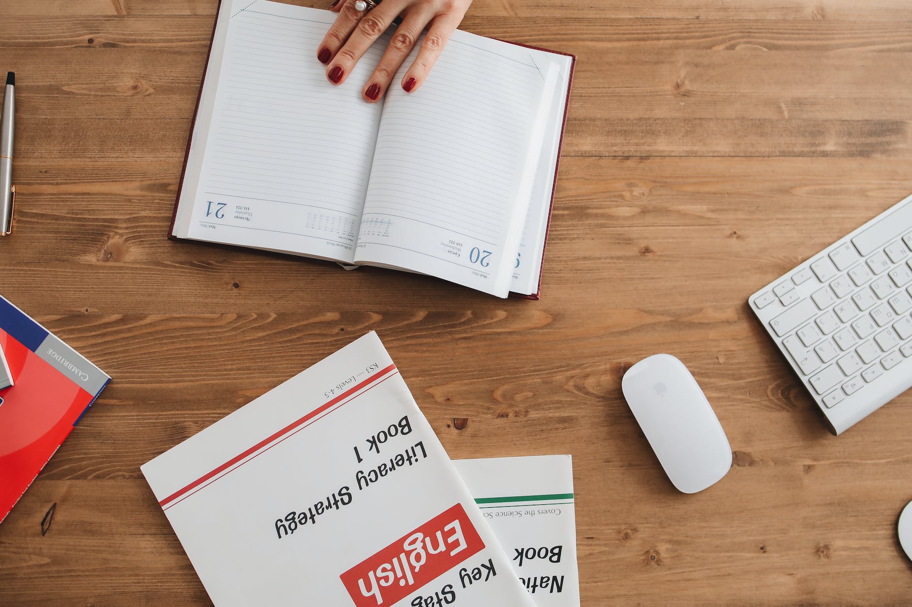 Top down view of english book and mouse and keyboard along with agenda